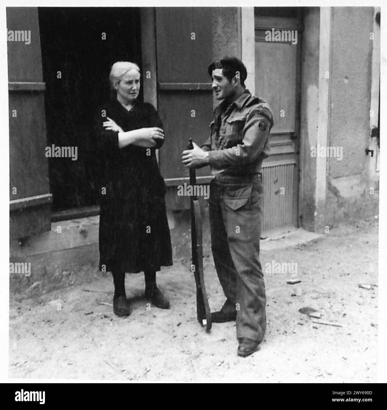 Un commando de marine français du 10 Commando (Inter-allié), rattaché au 4 Commando de la 1ère brigade de service spécial, s’entretient avec une femme civile à Amfreville le 9 juin 1944 lors de la campagne de Normandie. Banque D'Images