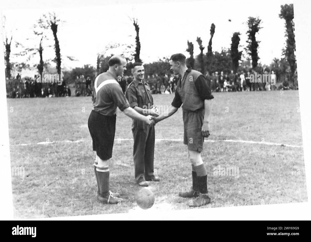 Les capitaines de football français et anglais se serrent la main avant le début d'un match de football du Bastille Day, illustrant l'esprit sportif amical entre les deux équipes. L'événement s'est déroulé sous la supervision de l'armée britannique, 21e groupe d'armées. Banque D'Images