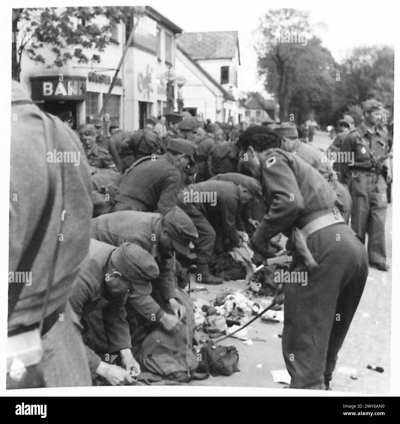 Les prisonniers SS allemands sont fouillés à leur arrivée en Allemagne sous la supervision du personnel de l'armée britannique, 1945. Banque D'Images