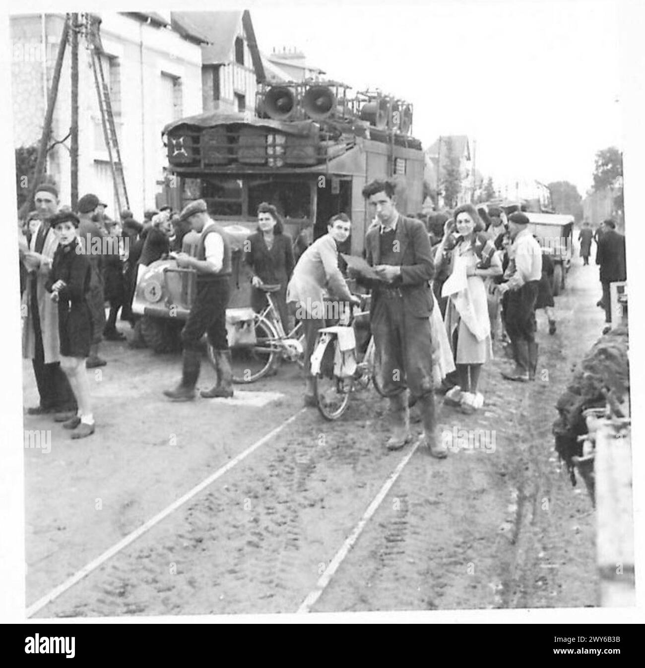 Les civils de Caen se rassemblent pour obtenir des exemplaires du journal de libération français "la voix des Alliés" après sa sortie. Banque D'Images