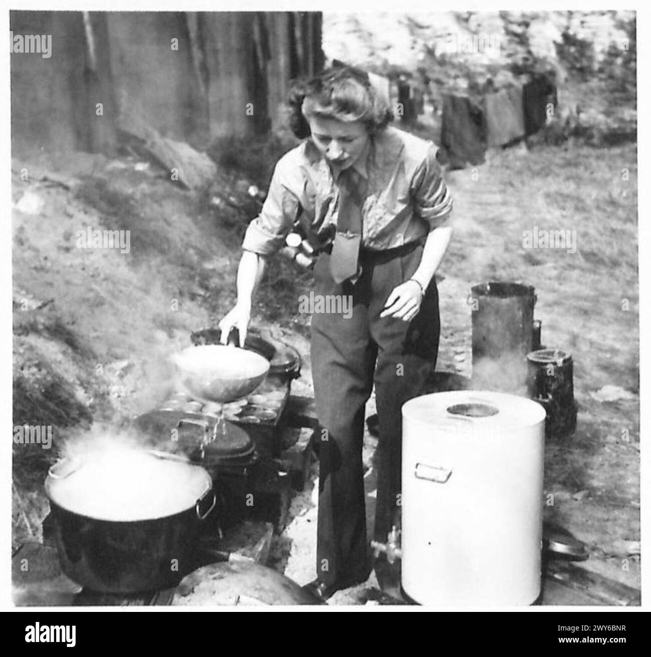 Miss Easwood transfère l'eau bouillie dans une urne à thé pour servir dans le van, illustrant les activités logistiques et de soutien de l'Y.M.C.A. avec les troupes britanniques. Banque D'Images