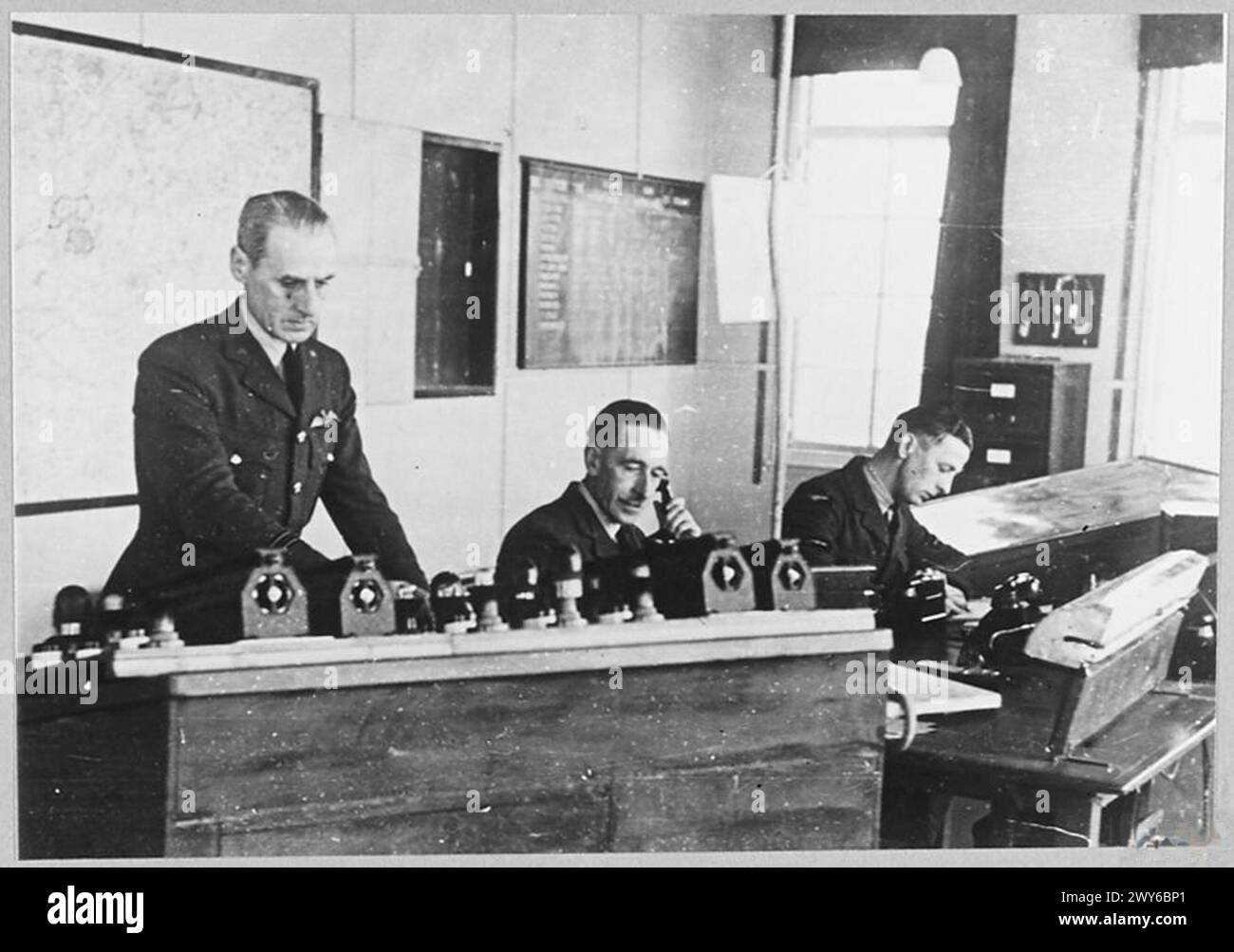Scènes à l'intérieur d'une tour de contrôle de station de la RAF montrant le personnel gérant le trafic aérien et les communications dans la salle de contrôle. Banque D'Images