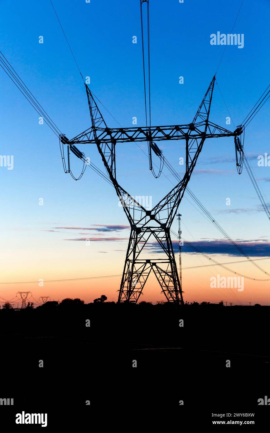 Tours de transmission haute tension au coucher du soleil Banque D'Images