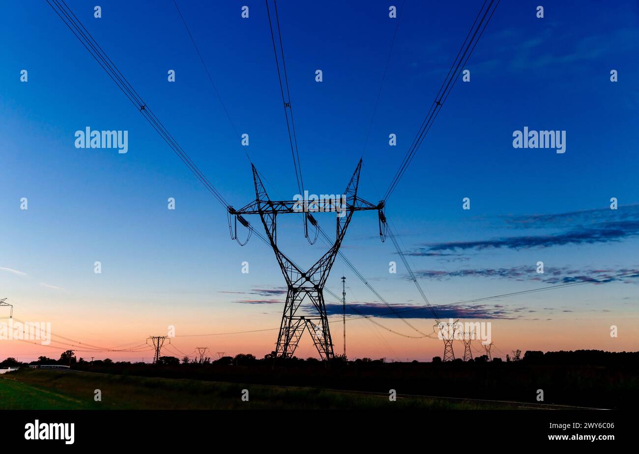 Tours de transmission haute tension au coucher du soleil Banque D'Images