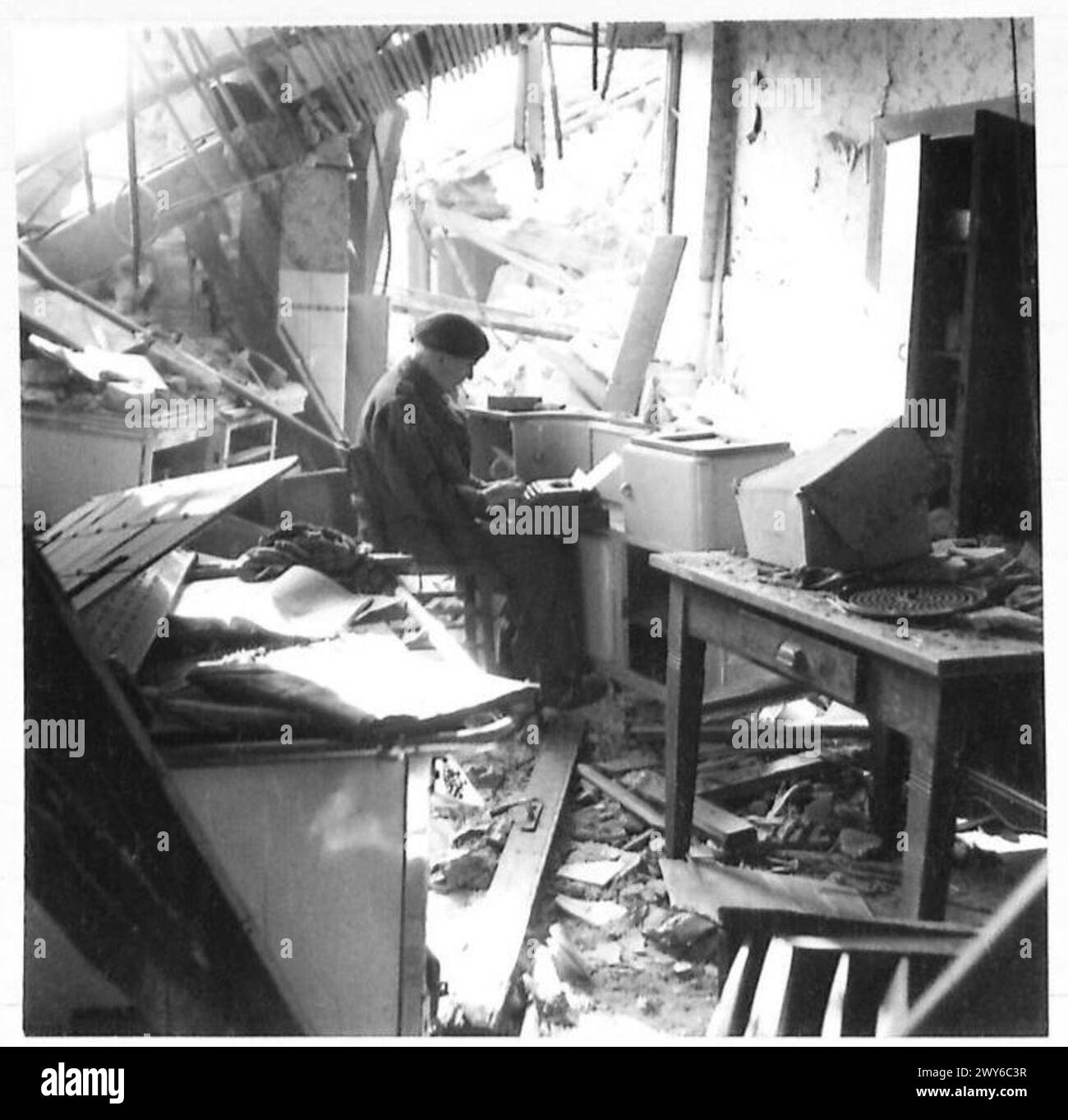 James McDonald, correspondant de guerre de New York, dresse des dépêches en Allemagne à partir des ruines d'une maison. Armée britannique, 21e groupe d'armées présent. Banque D'Images