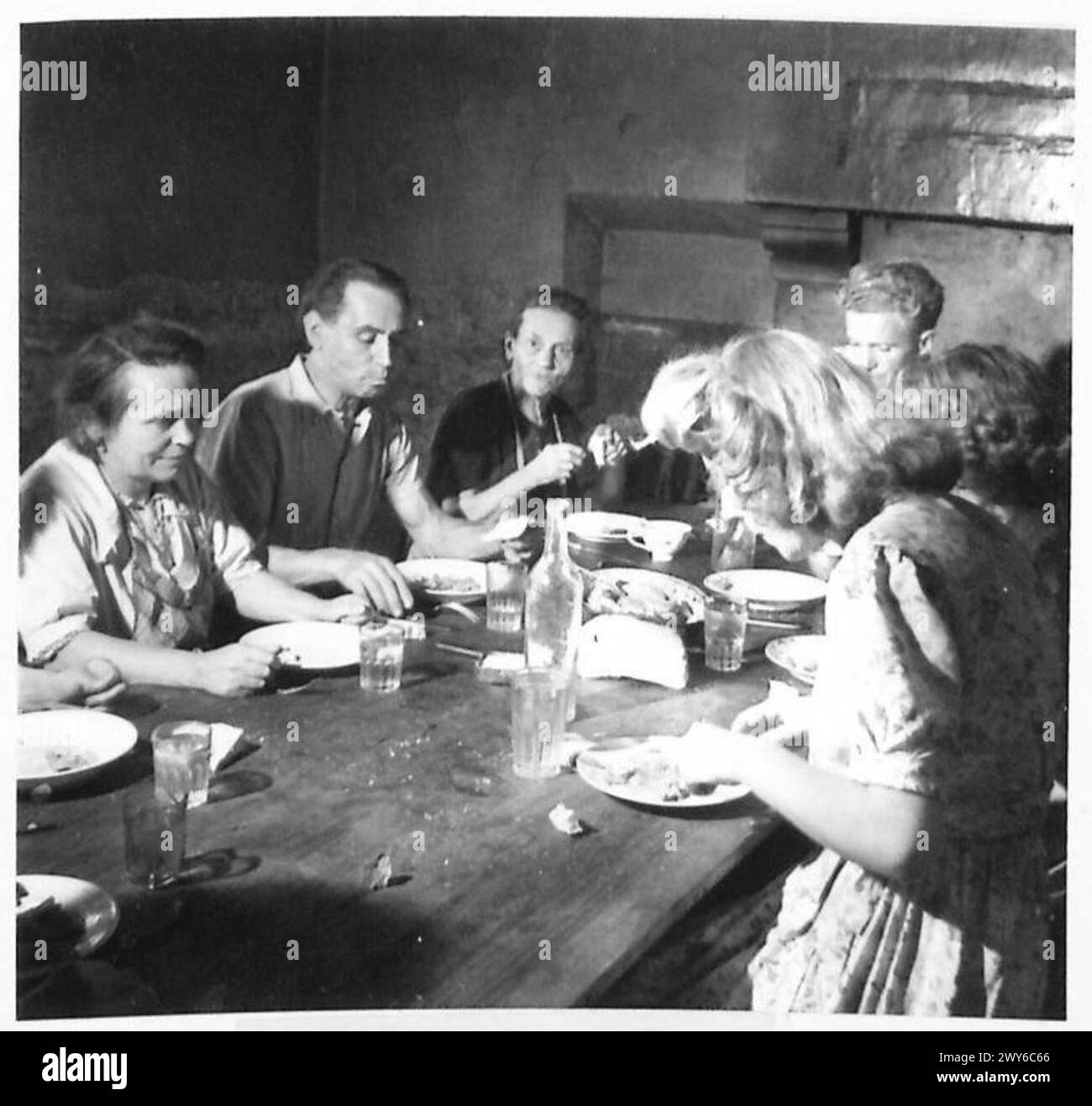 Une famille dans un village français est représentée en train de manger le soir, illustrant la vie quotidienne en France rurale pendant la présence des forces de l'armée britannique du 21e groupe d'armées. Banque D'Images