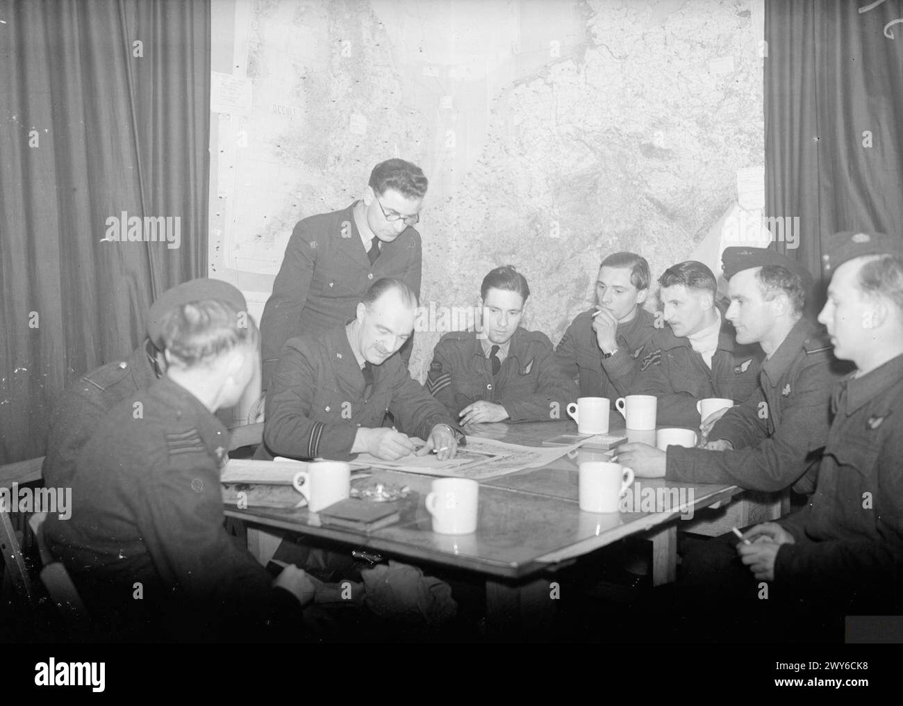 Un équipage Stirling du 7e escadron RAF est interrogé à Newmarket après un raid sur l'usine Renault à Billancourt, Paris, le 3-4 mars 1942. Le raid implique 235 avions et détruit avec succès une grande partie de l'usine, retardant la production de camions de plusieurs mois. Banque D'Images