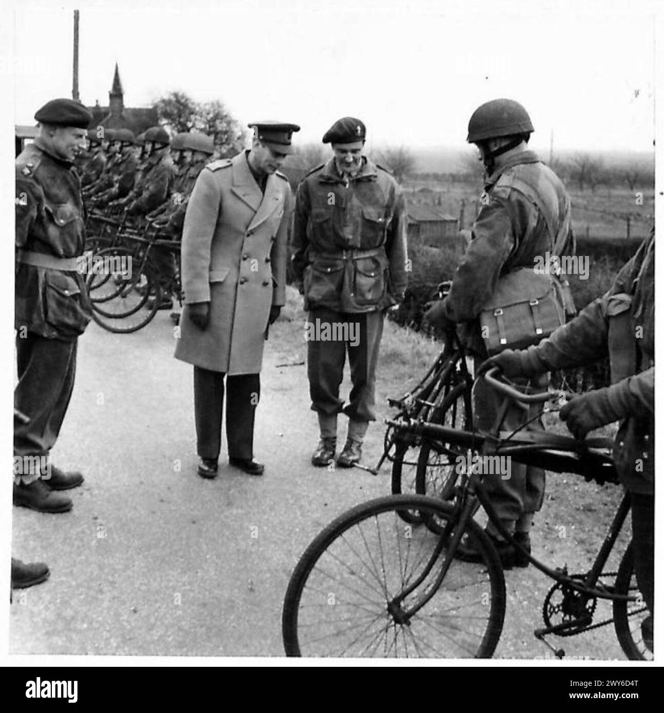 S.M. LE ROI VISITE LA DIVISION AÉROPORTÉE - le Roi a demandé une démonstration du vélo pliant porté par les parachutistes. Il lui a été montré bu Sapper J. Peden. , George VI, Roi, Armée britannique, Régiment de parachutistes Banque D'Images