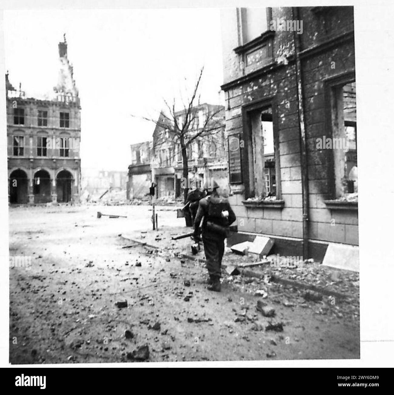 L'infanterie se déplace dans les rues dévastées de Bocholt, s'engageant dans des combats de rue pendant les opérations du 21e groupe d'armées britannique. Banque D'Images