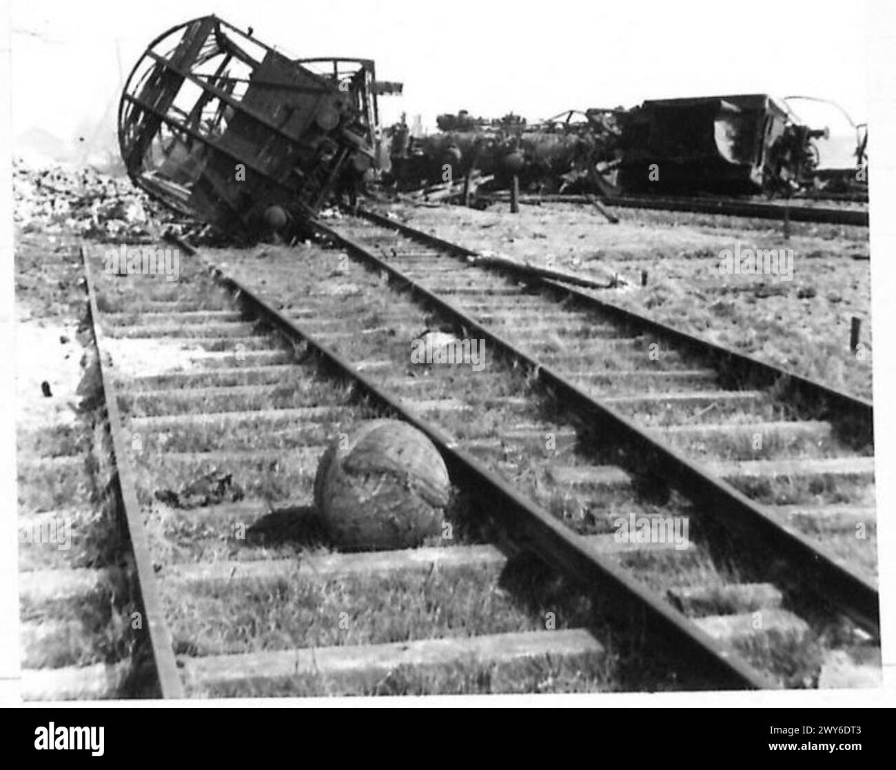 Un site d'armes détruit en Allemagne, avec des wagons incendiés et des restes d'usine, représentant les conséquences des engagements militaires dans le nord-ouest de l'Europe. Banque D'Images