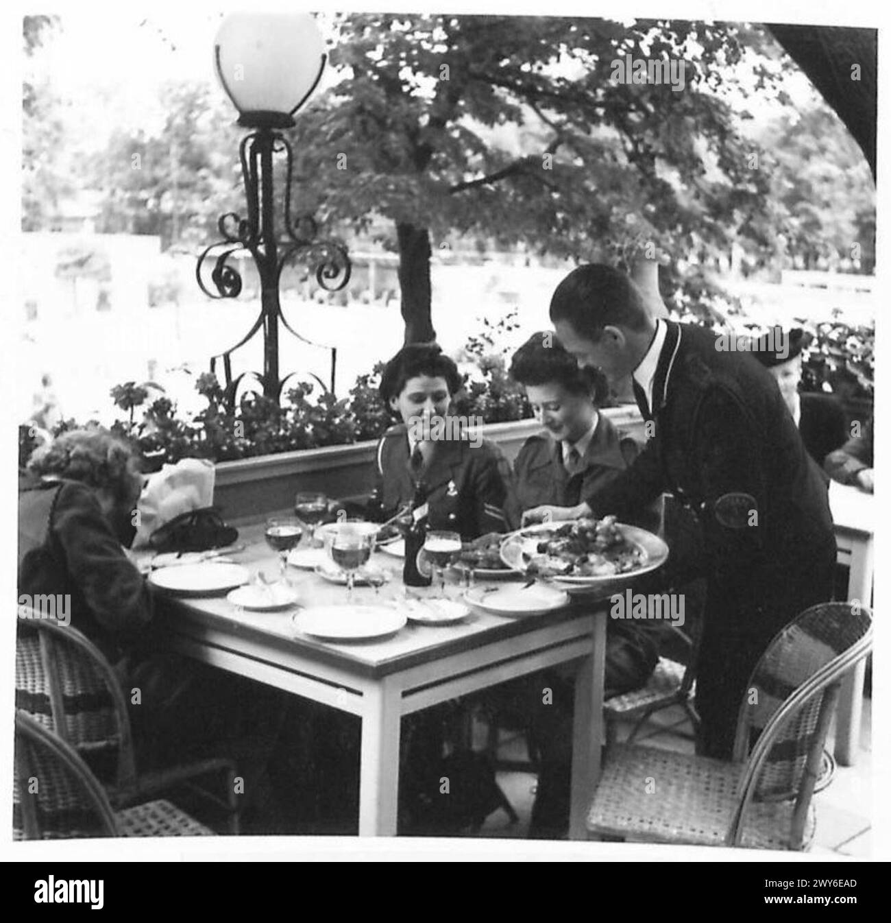 Les membres du Service territorial auxiliaire déjeunent à l'extérieur au Tivoli à Copenhague, mangeant du poulet rôti, des pommes de terre, des champignons, des fraises, et de la crème glacée, armée britannique, 21e groupe d'armées. Banque D'Images