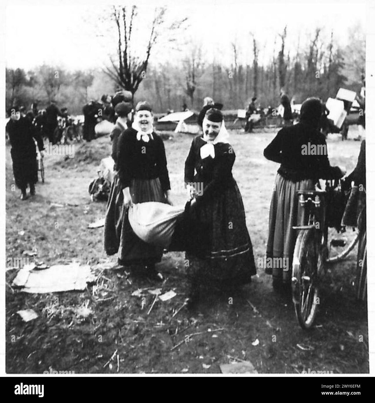 Des civils allemands et des esclaves alliés pillent des barges de fromage, de vin, de graisse, de farine et de riz sur un canal, en utilisant tous les moyens de transport disponibles pour transporter des marchandises. Banque D'Images