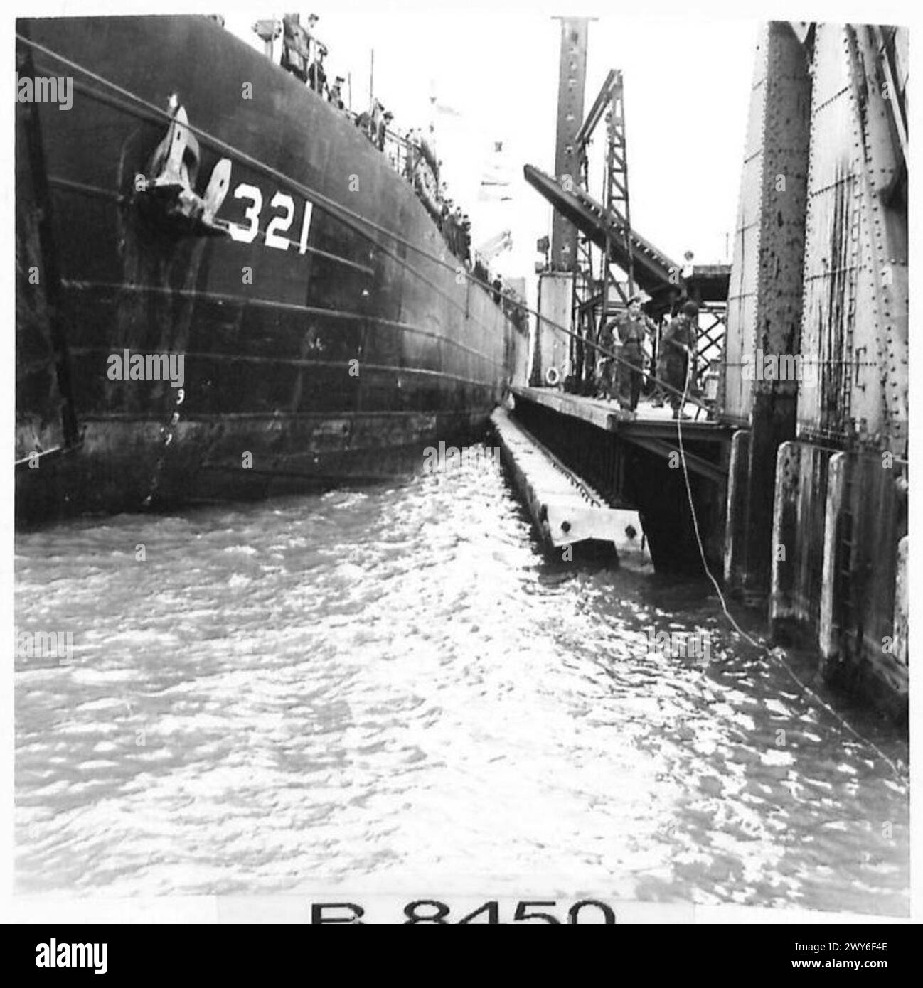 Un LST (Landing Ship, Tank) vient aux côtés du Pierhead dans une installation portuaire préfabriquée, British Army, 21st Army Group. Banque D'Images