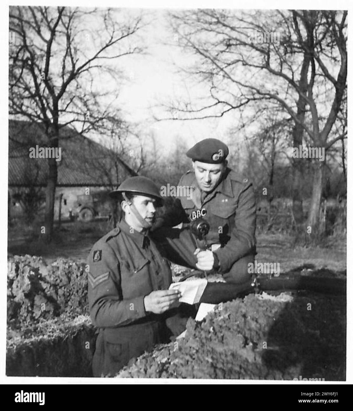 Un caporal de l'armée britannique livre un message de diffusion saisonnière aux civils à la maison, partageant des salutations et une communication stimulant le moral en temps de guerre, sous la supervision du 21e groupe d'armées. Banque D'Images