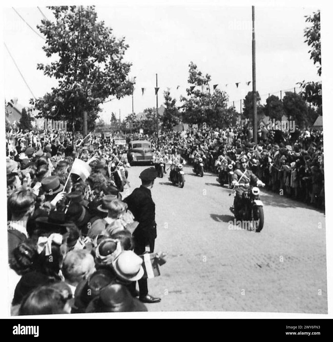 La princesse Juliana arrive à un stade de Nimègue dans une voiture royale escortée par des cyclistes de C.M.P. pour inspecter les Kensingtons et recevoir un cadeau pour la Croix-Rouge néerlandaise. Banque D'Images