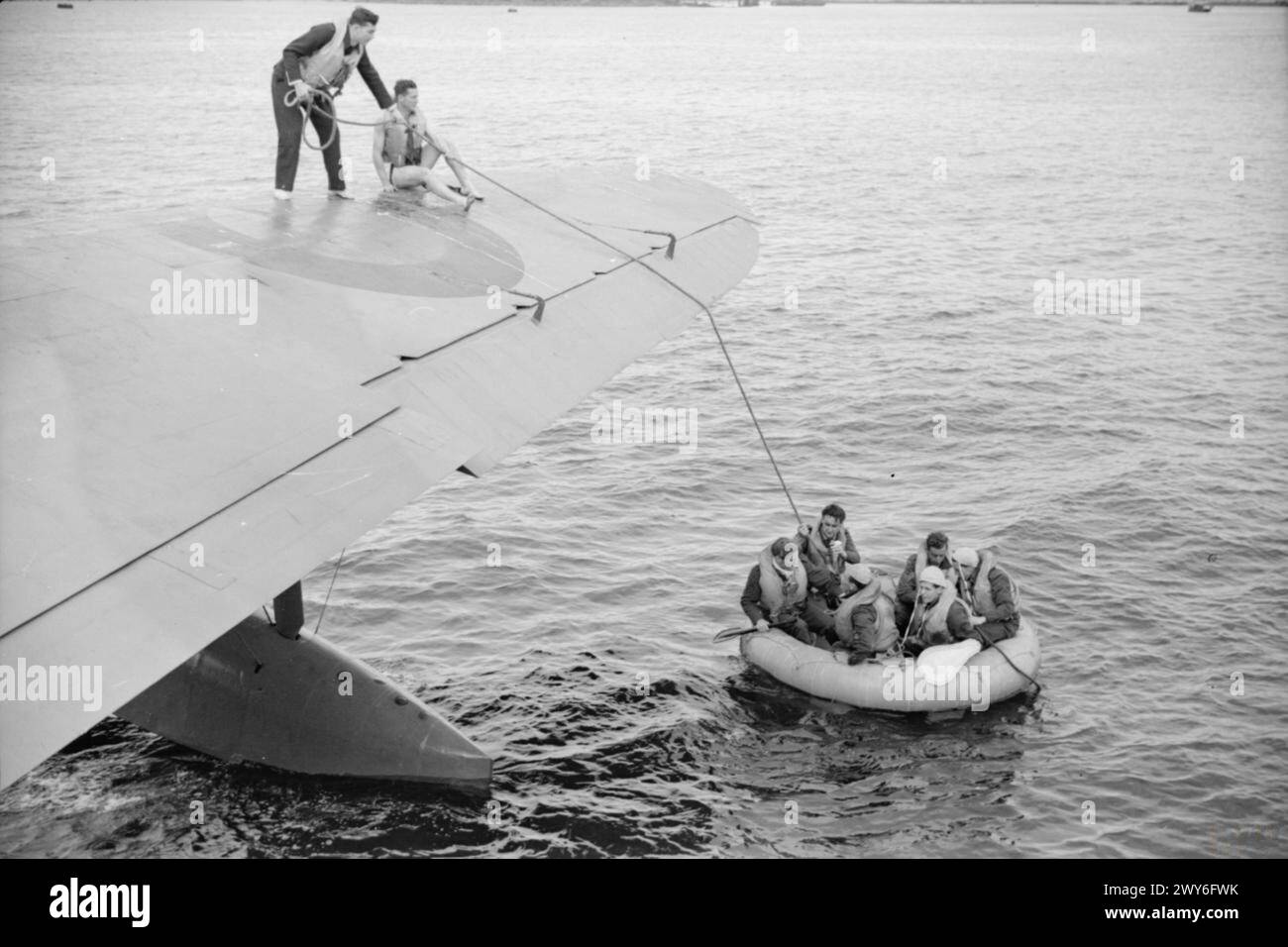 ROYAL AIR FORCE 1939-1945, COASTAL COMMAND - débarquer un Sunderland sur l'océan était lourd de danger, car sa coque mince et ses surfaces planantes n'ont jamais été conçues pour résister à un battement de grandes vagues et de mers lourdes. Malgré cela, de nombreux équipages sont descendus pour ramasser les survivants des avions abattus. Un incident de ce type s'est produit dans le golfe de Gascogne le 13 juillet 1942, lorsqu'un équipage du No 77 Squadron Whitley a été récupéré par un Sunderland du No 461 Squadron RAAF nouvellement formé. Cette scène a été l'une des nombreuses reconstruites plus tard au Mont Batten pour le bénéfice d'un photographe officiel. , Ro Banque D'Images