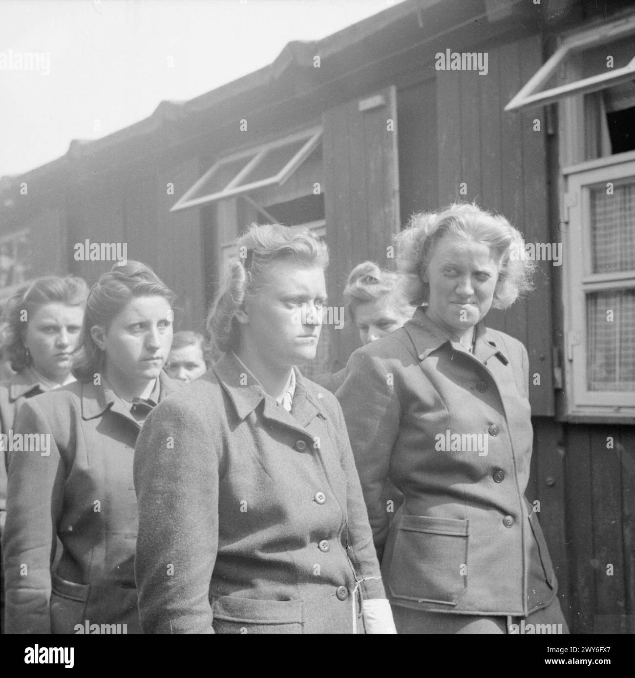 LA LIBÉRATION DU CAMP DE CONCENTRATION DE BERGEN-BELSEN, AVRIL 1945 - les gardes SS du camp sont défilées pour travailler à nettoyer les morts. Les femmes comprennent Hildegard Kanbach (première à partir de la gauche), Irene Haschke (au centre, troisième à partir de la droite), la gardienne principale, Elisabeth Volkenrath (deuxième à partir de la droite, partiellement cachée) et Herta Bothe (première à partir de la droite). , Banque D'Images
