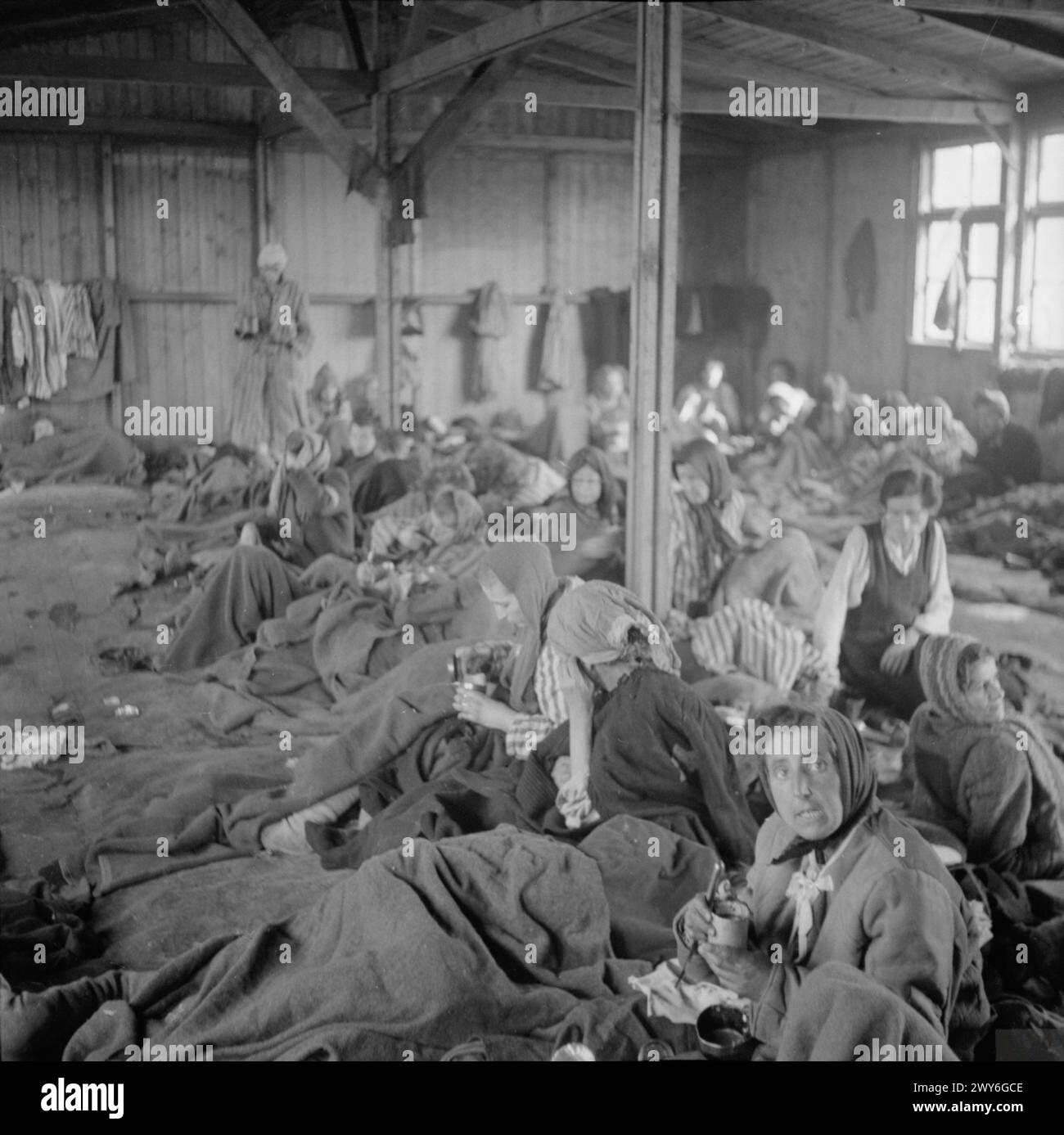 LA LIBÉRATION DU CAMP DE CONCENTRATION DE BERGEN-BELSEN, AVRIL 1945 - les détenues souffrant du typhus reçoivent de l'eau potable dans l'une des cabanes du camp, Banque D'Images