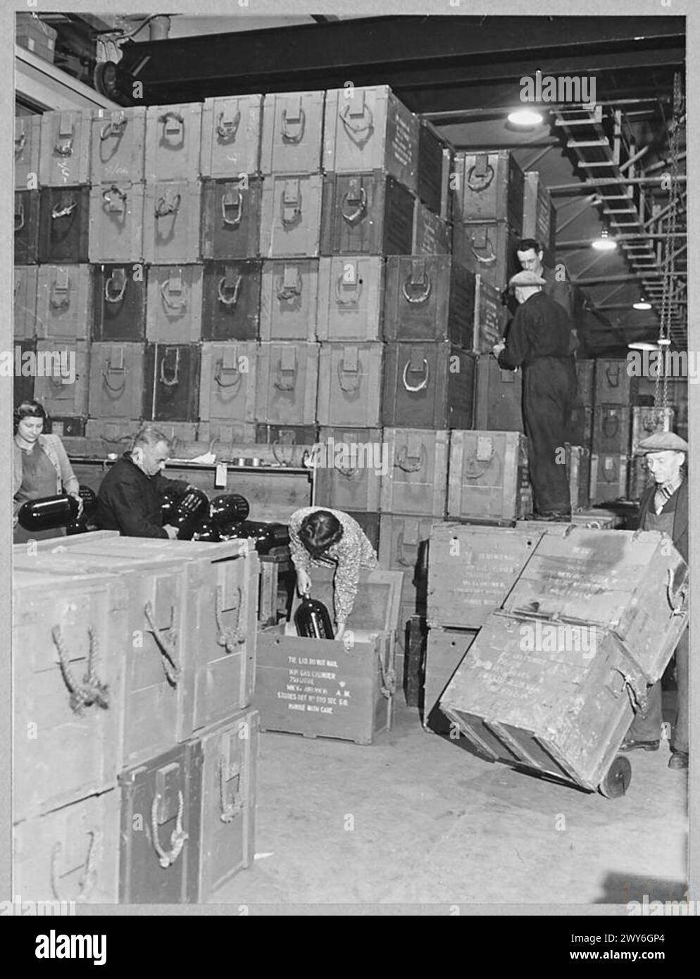 Le personnel de l'unité de maintenance de la Royal Air Force manipule des bouteilles d'oxygène de 750 litres dans la section des instruments pour soutenir les avions de chasse en 1943. Banque D'Images