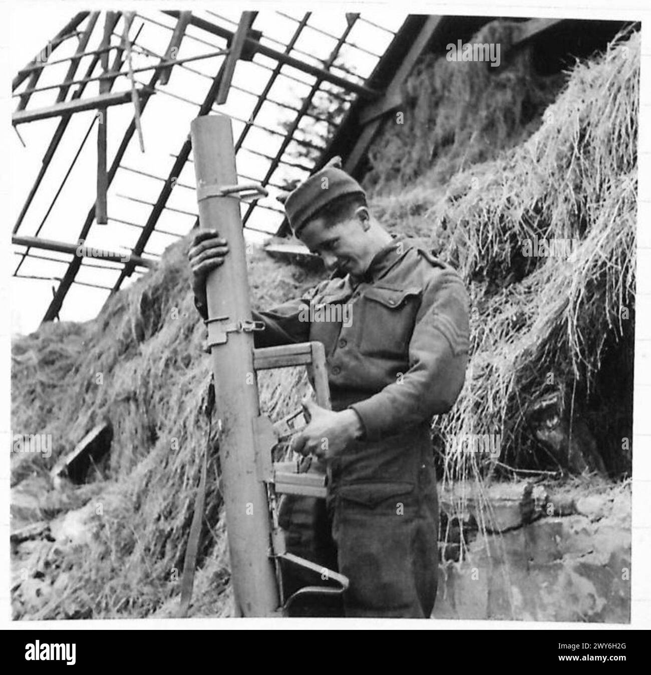 Le sergent J. Sullivan de Stoke-on-Trent inspecte un canon de lancement de bombes abandonné laissé lors d'un retrait de l'armée britannique du 21e groupe d'armées. Banque D'Images