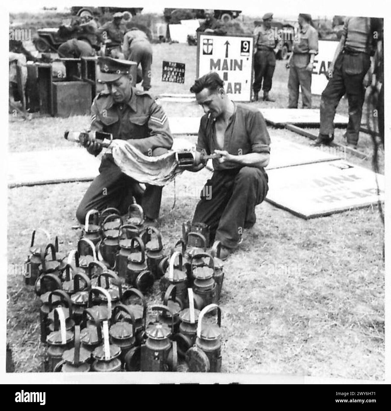 Les lampes sont nettoyées et préparées par le corps de la police militaire en Normandie pour être utilisées dans les opérations de contrôle routier en 1944. Banque D'Images