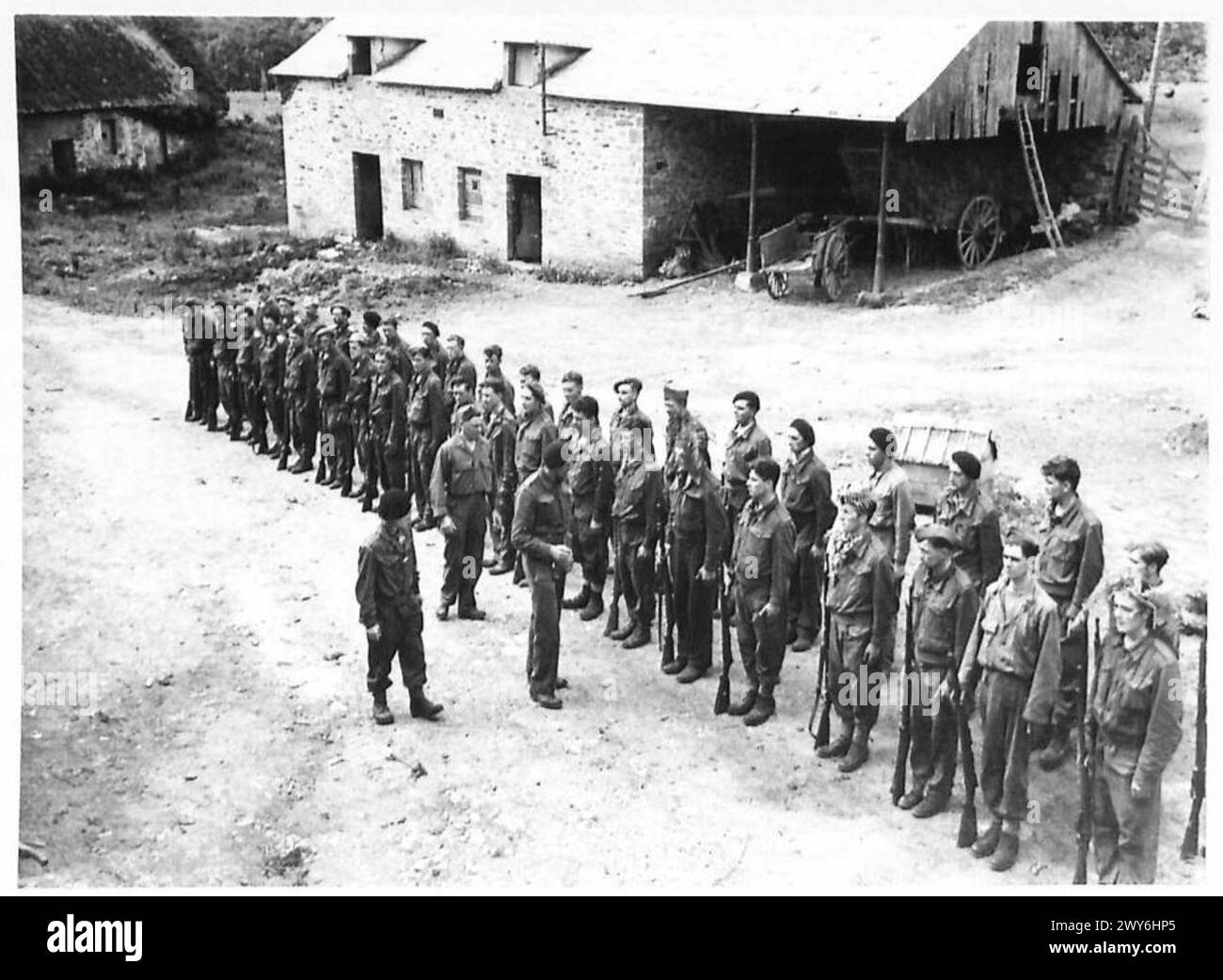 Une unité « Commando » parcourt dans une cour de ferme avant un entraînement à la guerre offensive sous la supervision du 21e groupe d'armées britannique. Banque D'Images