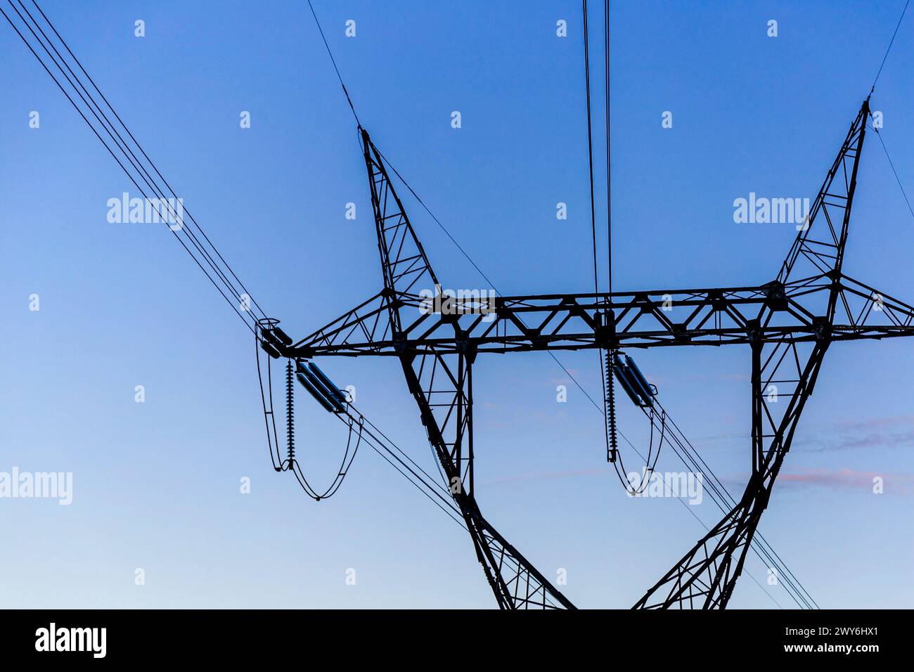 Détail d'une tour de transmission haute tension au coucher du soleil Banque D'Images