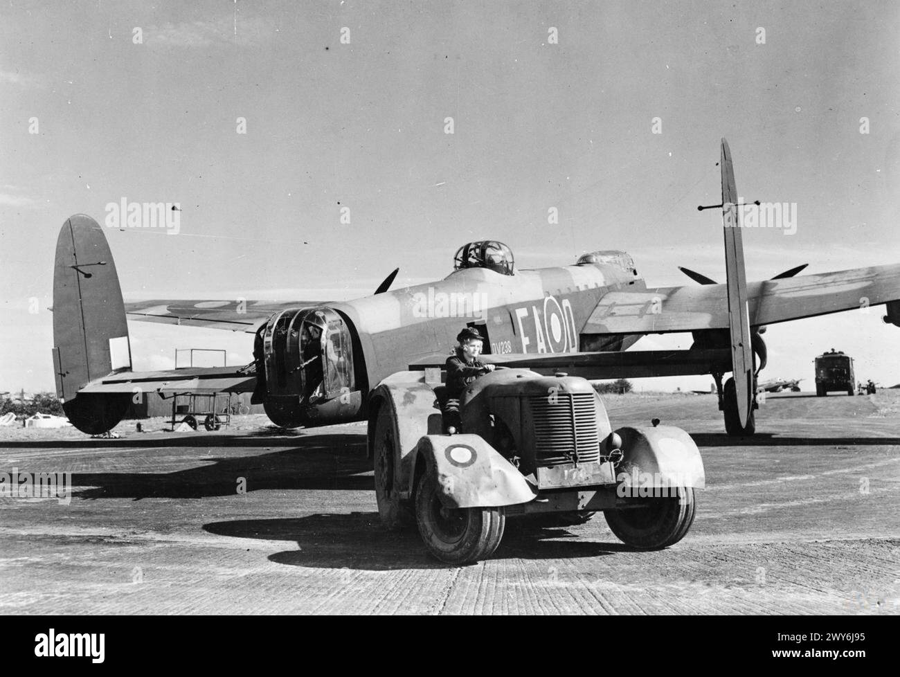 COMMANDEMENT DES BOMBARDIERS DE LA ROYAL AIR FORCE, 1942-1945. - Aircraftwoman Lilian Yule Tractors Avro Lancaster B Mark III, DV238 'EA-O', du No. 49 Squadron RAF à sa fente de dispersion à Fiskerton, Lincolnshire. DV238 est ensuite allé au No. 44 Squadron RAF avec qui il a été perdu lors d'un raid sur Berlin le 16/17 décembre 1944, Royal Air Force, Royal Air Force Regiment, Sqdn, 49, Royal Air Force, Royal Air Force Regiment, Sqdn, 44, Royal Air Force, Women's Auxiliary Air Force Banque D'Images