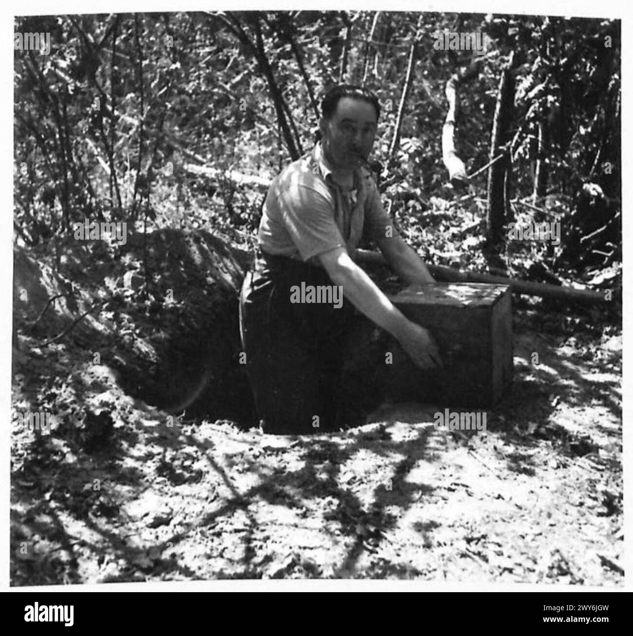 Une famille française découvre des objets de valeur, y compris une boîte de couverts, enterrés dans un bois voisin après être rentrés chez eux, documentés par l'armée britannique, 21e groupe d'armées. Banque D'Images