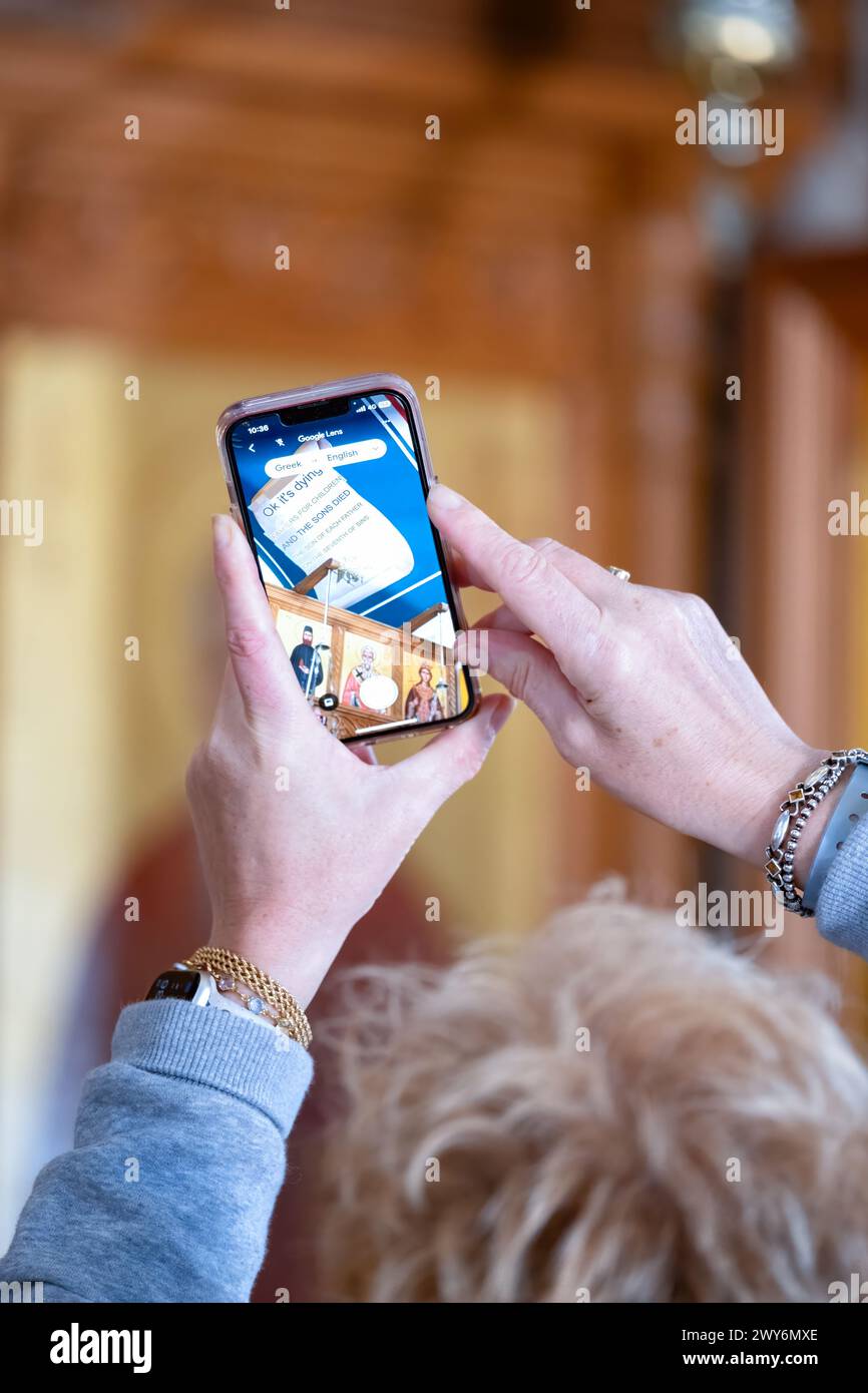 Paphos Chypre. Une touriste utilise l'application Google Translate sur son téléphone portable pour traduire du texte grec, sur un plafond d'église, en texte anglais Banque D'Images