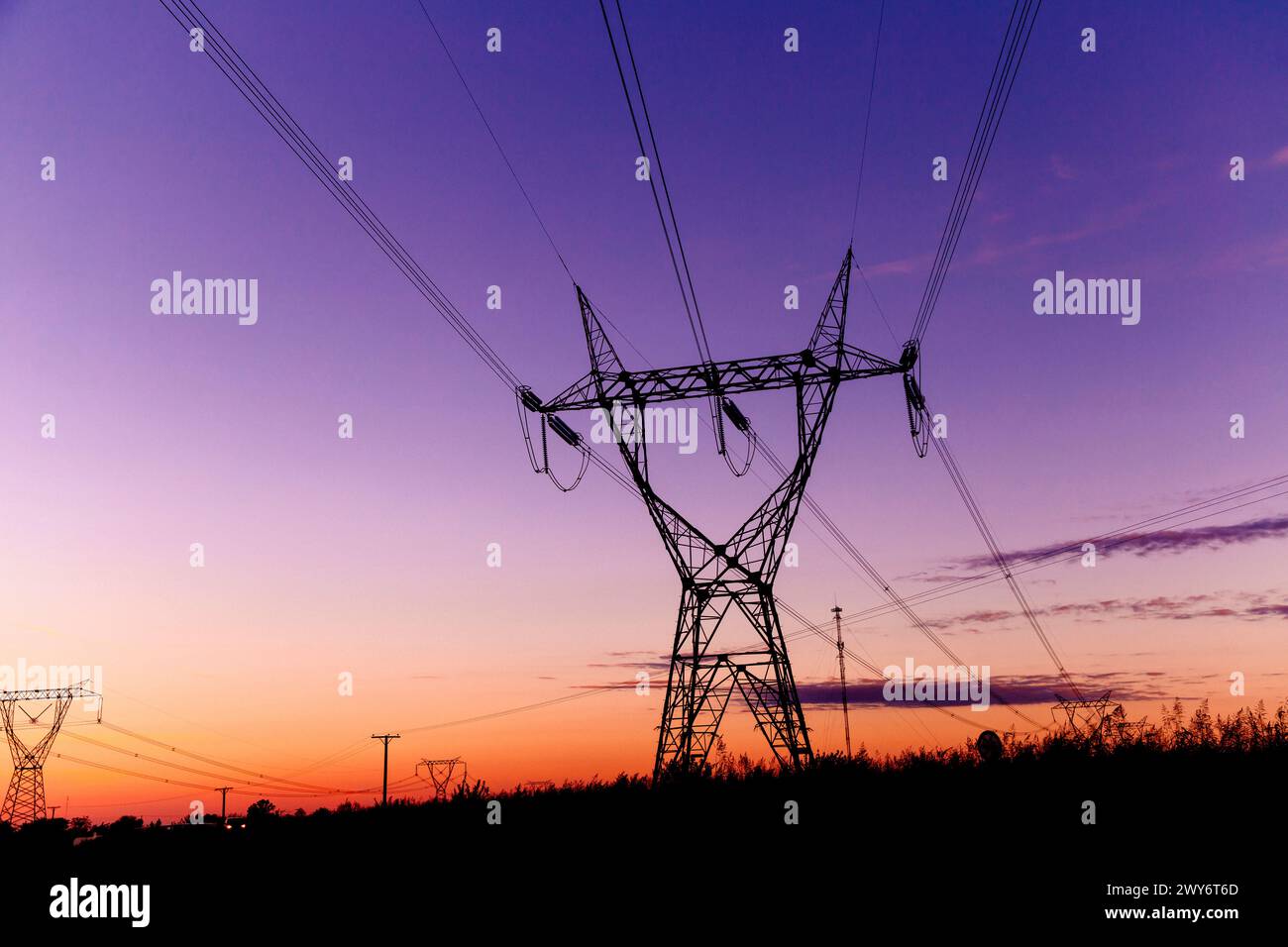 Tours de transmission haute tension au coucher du soleil Banque D'Images