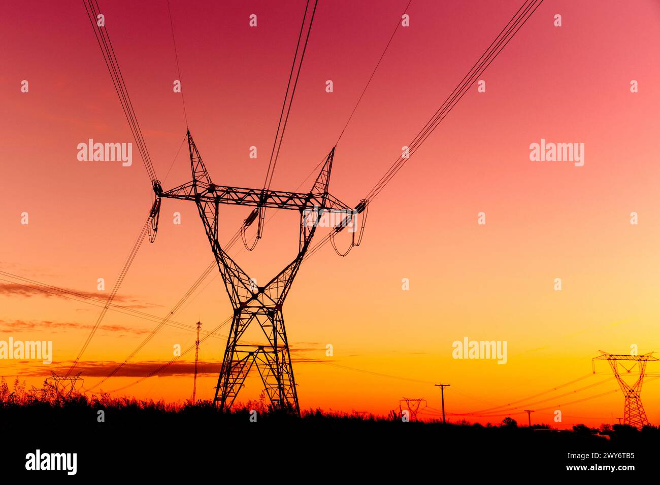 Tours de transmission haute tension au coucher du soleil Banque D'Images