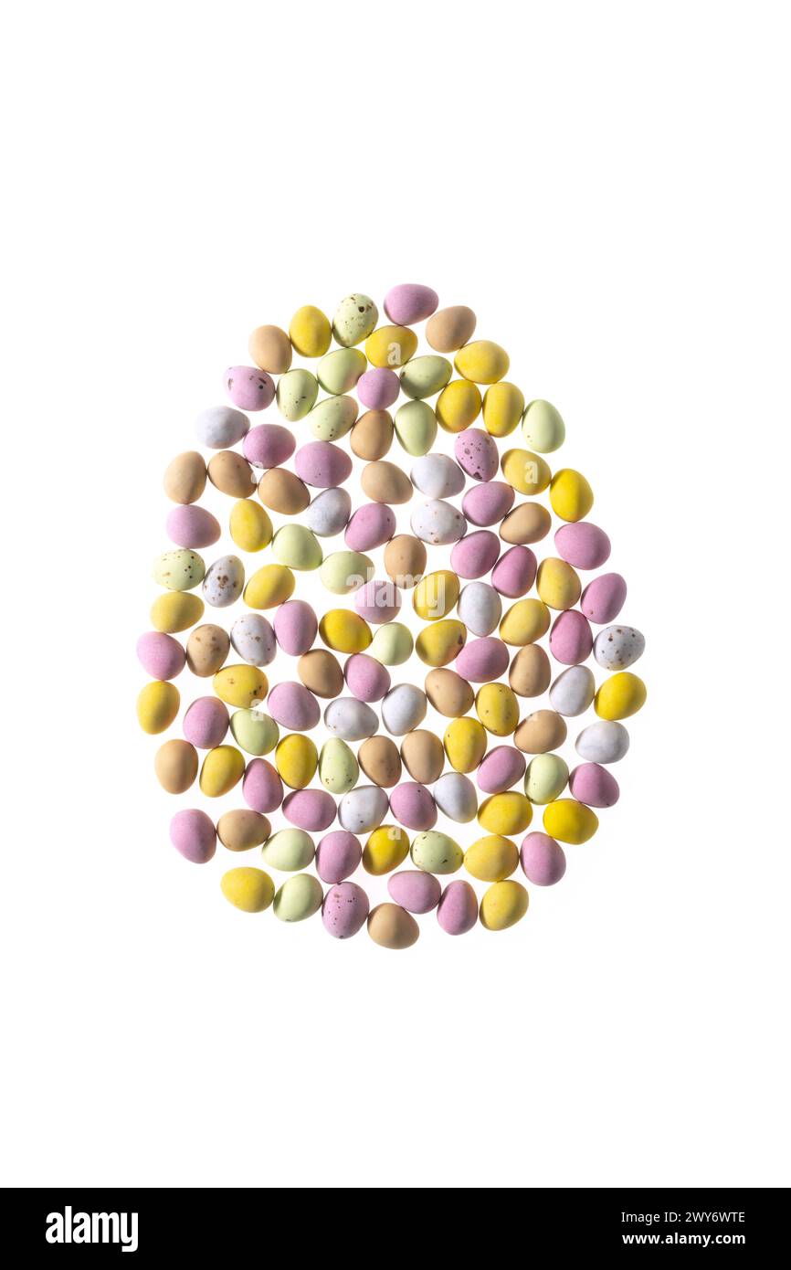Mini oeufs enrobés de sucre coloré disposés en forme d'oeuf sur un fond blanc Banque D'Images