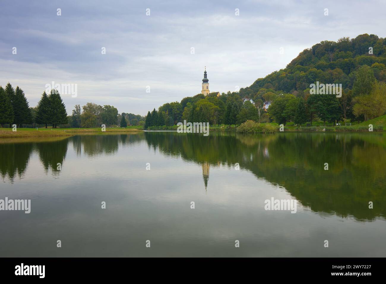 Vue sur le lac de baignade jusqu'à l'église paroissiale catholique de équipé Magdalena à Wildon, Autriche. Banque D'Images