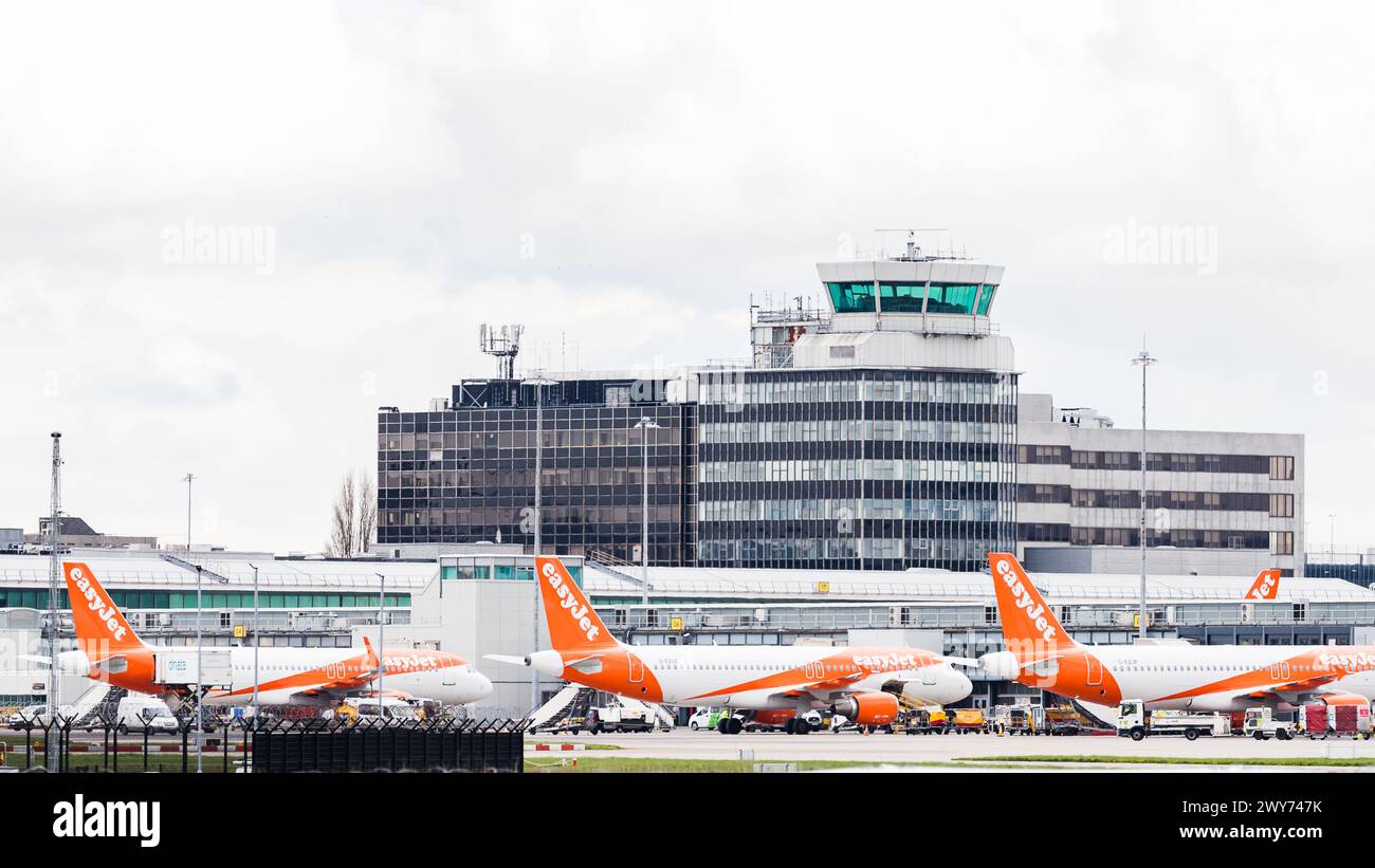 Trois Airbus A320-214 Easyjet photographiés dans un terminal sous la tour de contrôle de l'aéroport de Manchester le 4 avril 2024. Banque D'Images