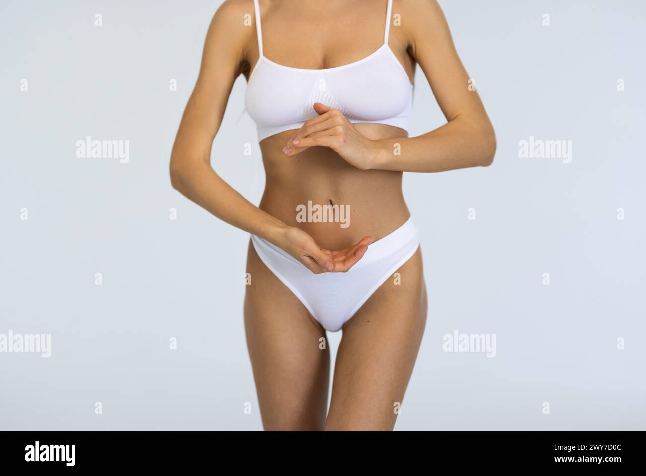 Régime. Image recadrée d'un corps féminin mince et sain, sein, ventre sur fond gris de studio. Mannequin posant en sous-vêtements blancs. Concept de corps et SK Banque D'Images