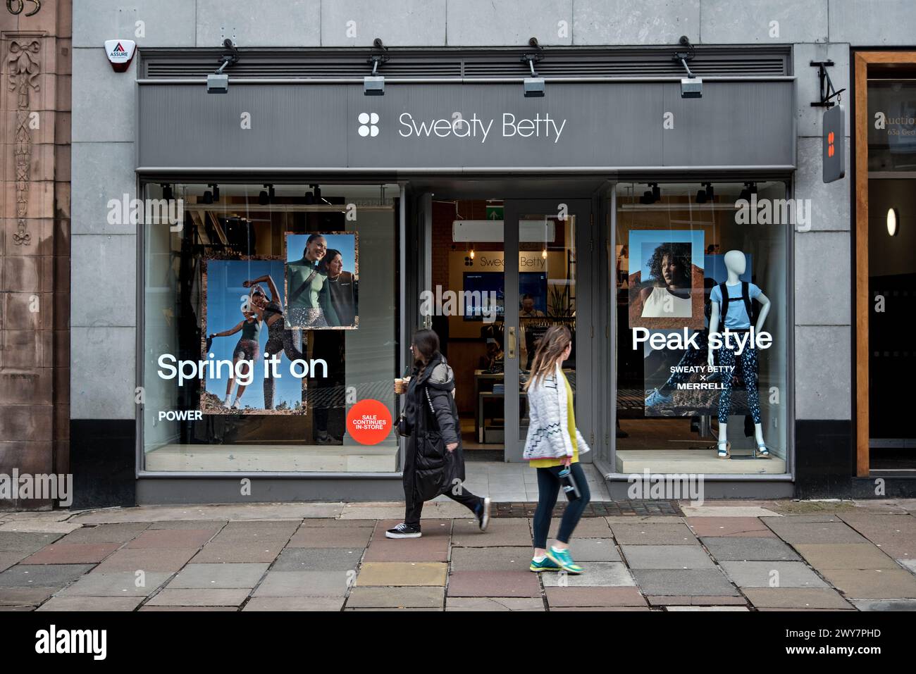 Deux jeunes femmes marchant près du magasin Sweaty Betty à George Street, Édimbourg, Écosse, Royaume-Uni. Banque D'Images