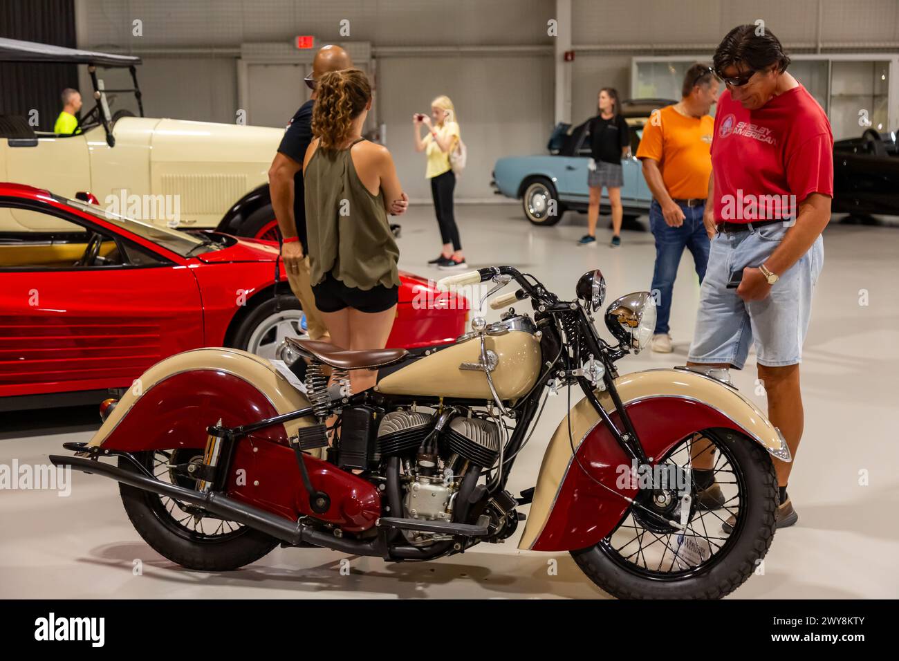 Un homme inspecte une moto Indian Sport Scout rouge et blanche de 1942 exposée à la vente aux enchères Auburn 2022 de Worldwide Auctioneers à Auburn, Indiana, États-Unis. Banque D'Images