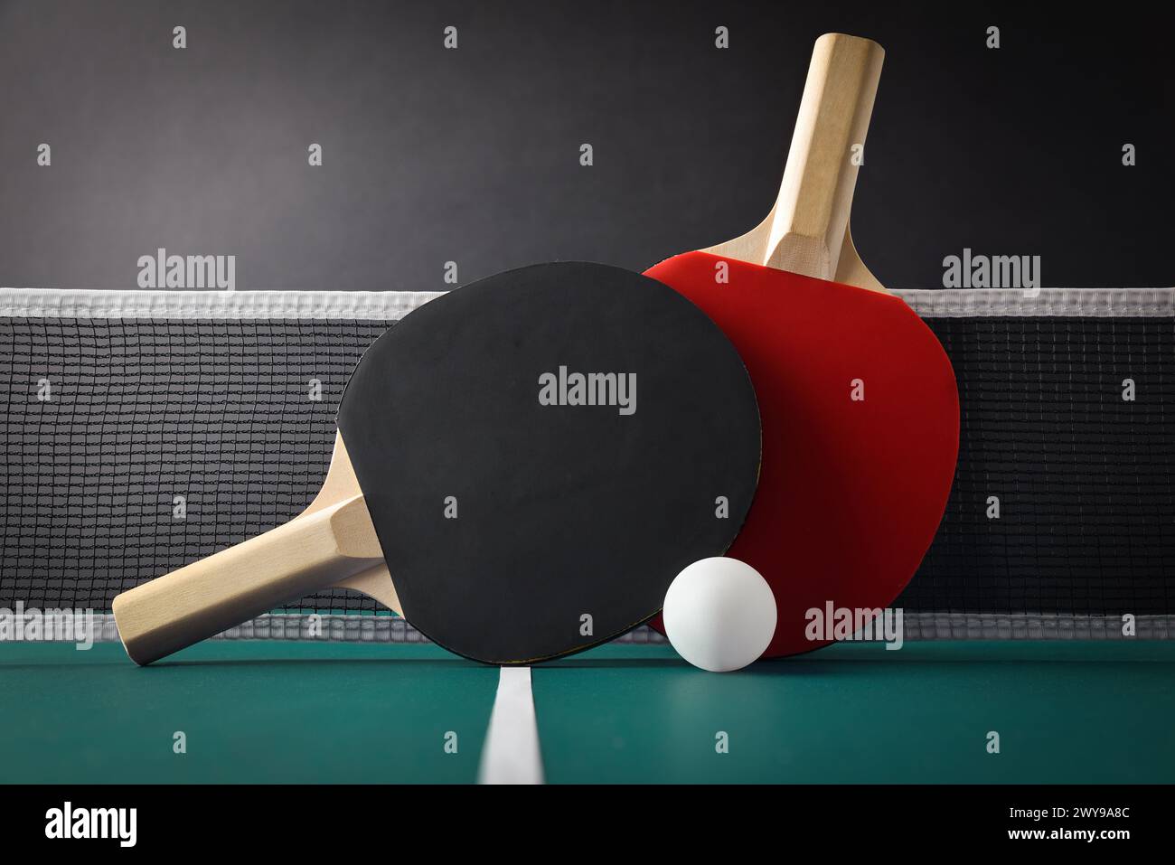 Vue de l'ensemble professionnel de ping-pong avec des pagaies reposant sur le filet sur la table de jeu verte avec balle blanche. Vue de face. Banque D'Images