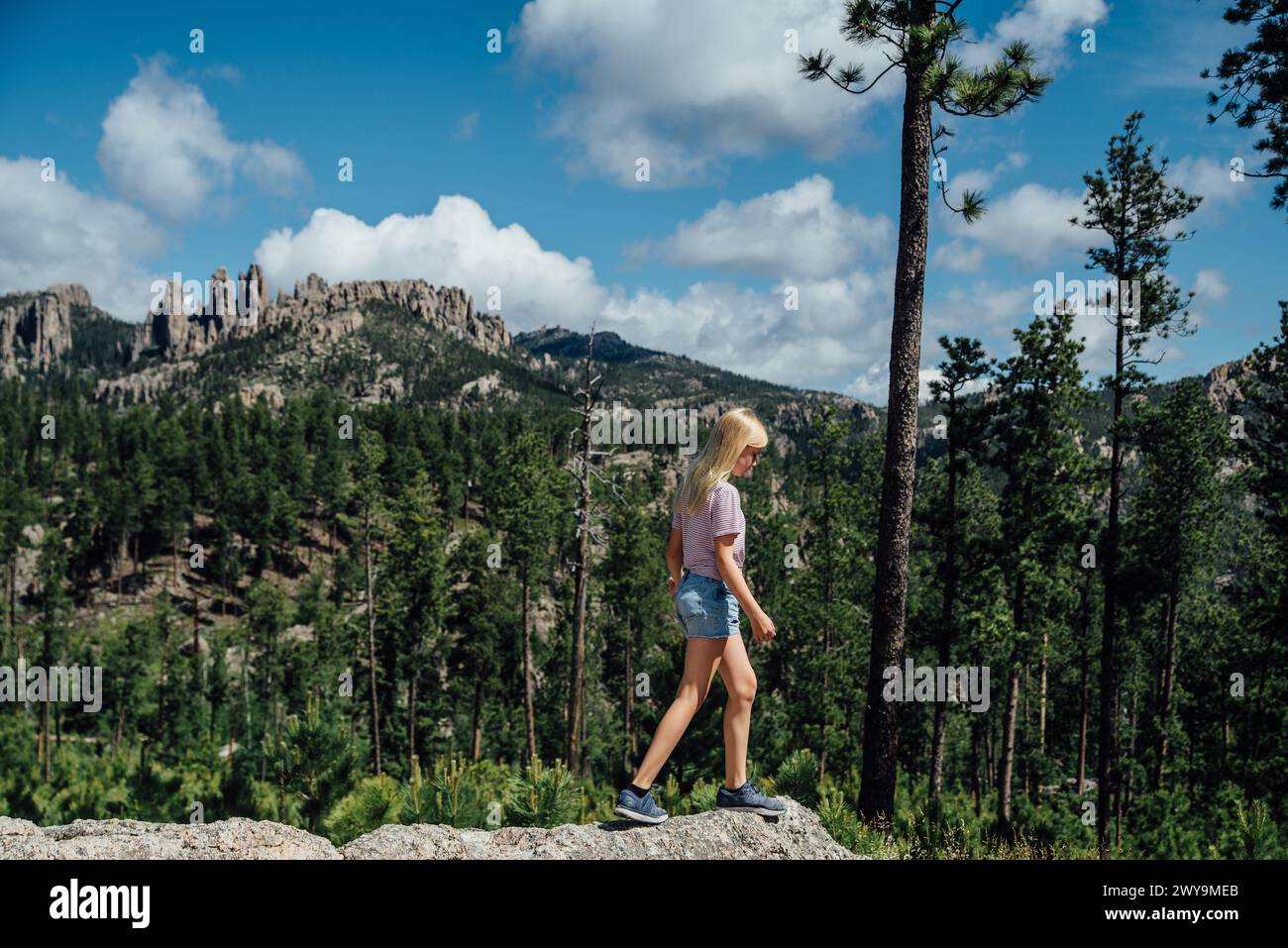 Vue latérale de preteen devant les montagnes sur l'après-midi ensoleillé d'été Banque D'Images