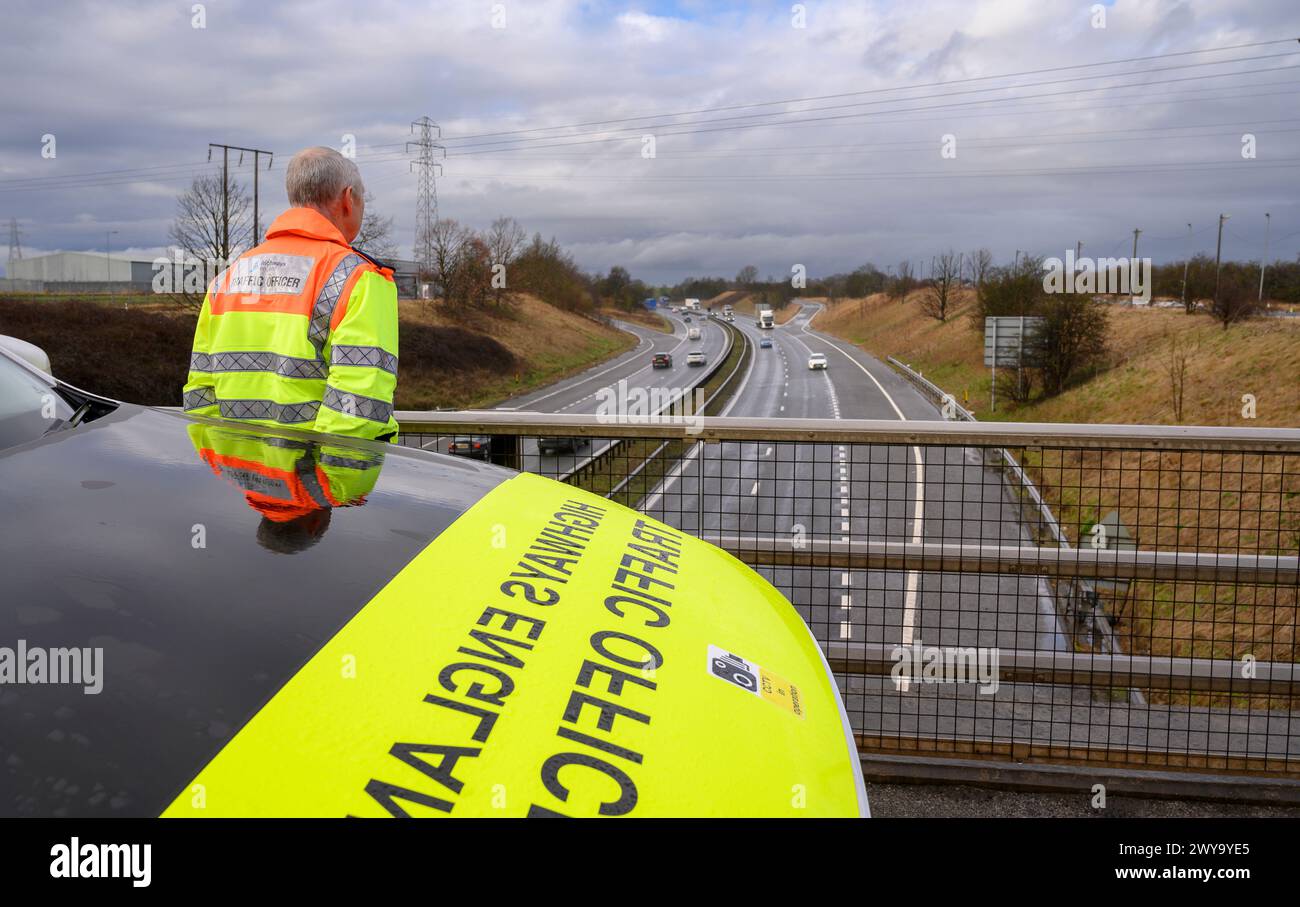 Highways England officier de la circulation observant le flux de la circulation depuis un pont sur l'A1M, Angleterre. Banque D'Images