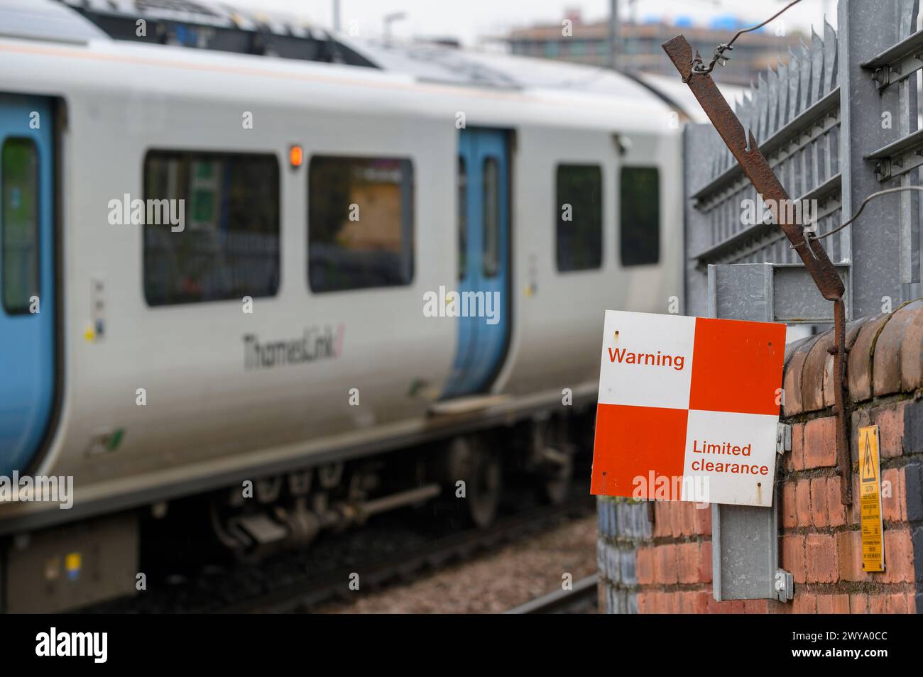 Train de voyageurs Thameslink Class 700 passant un panneau d'avertissement à la gare de West Hampstead, Londres, Angleterre. Banque D'Images