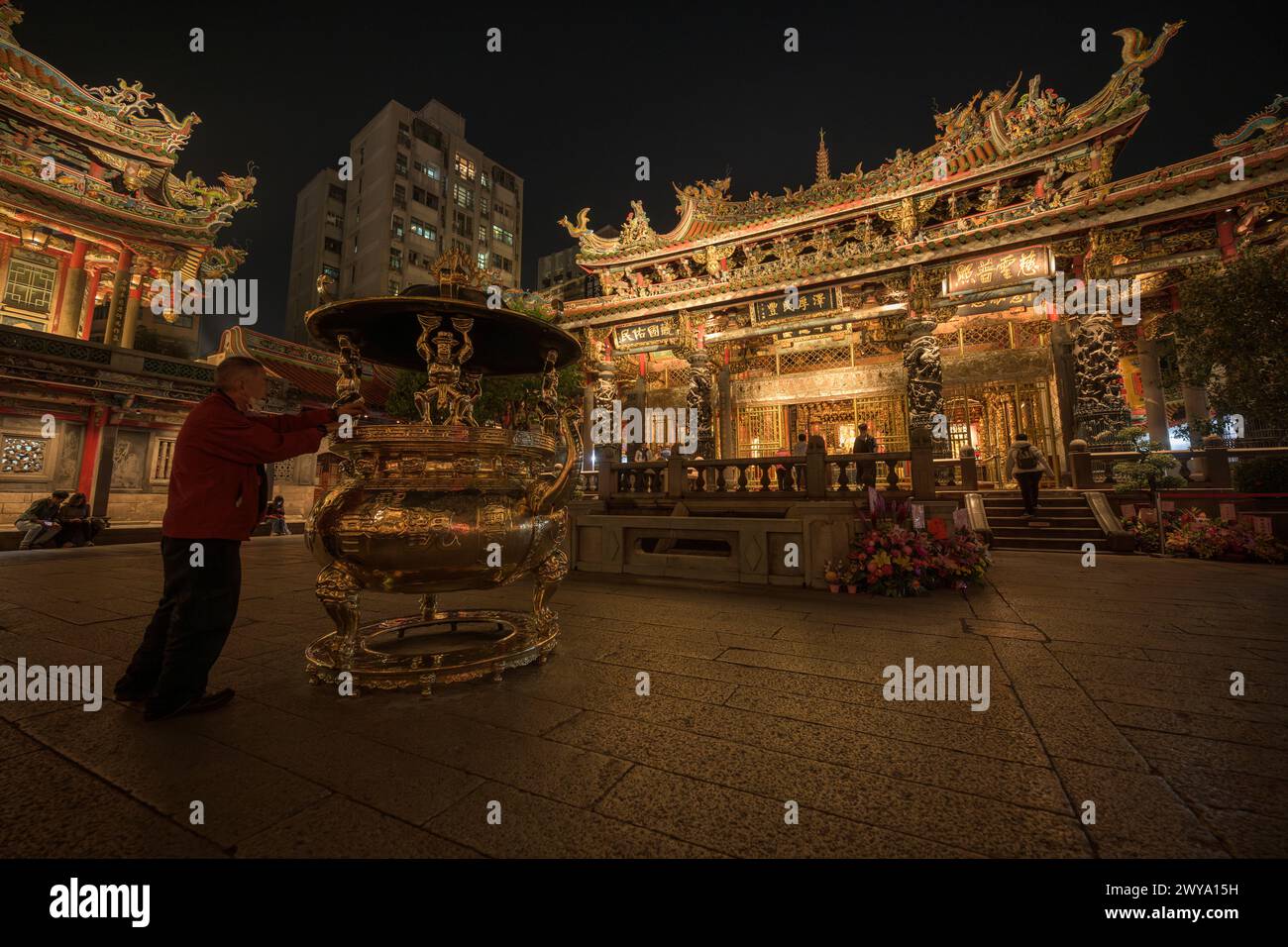 Un temple Longshan richement décoré la nuit rempli de fleurs et de statues d'or Banque D'Images