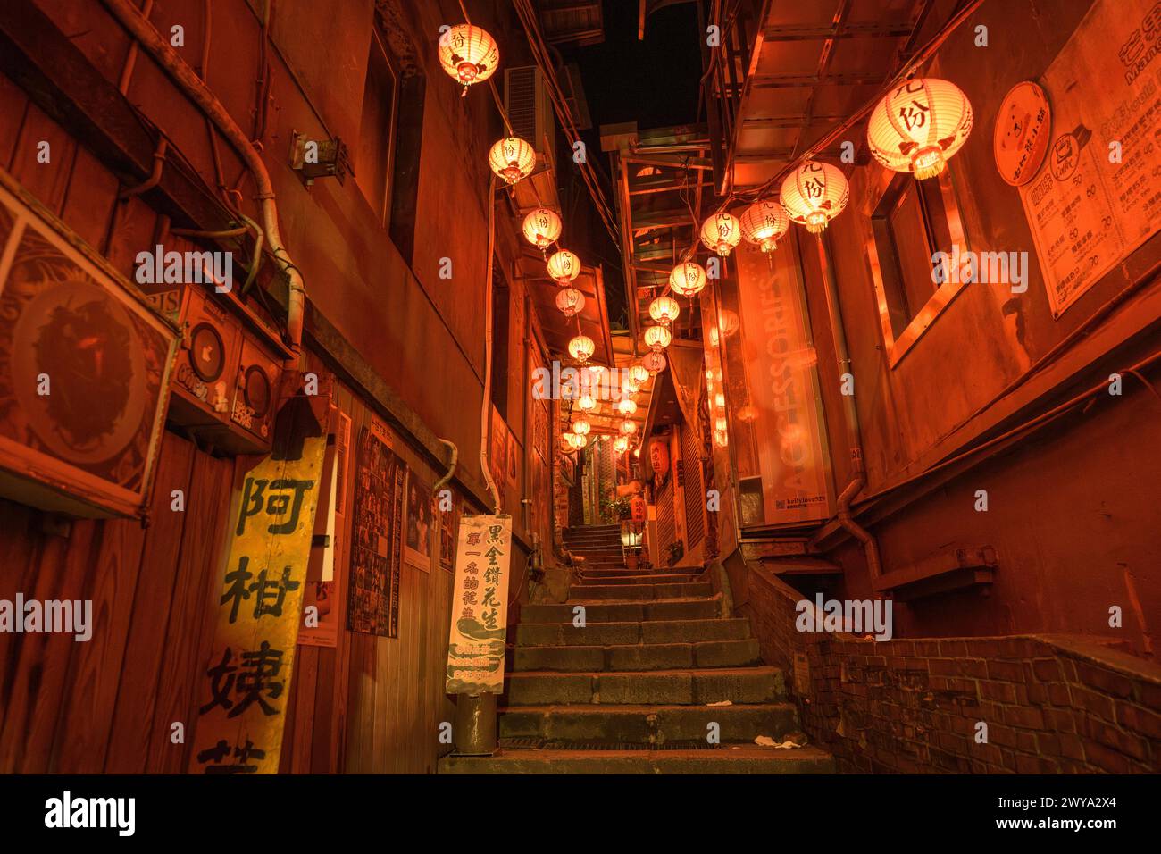 Une ruelle respire le charme avec une série de lanternes rouges guidant le chemin vers le haut des escaliers de pierre, dans les rues désertes de Jiufen Banque D'Images