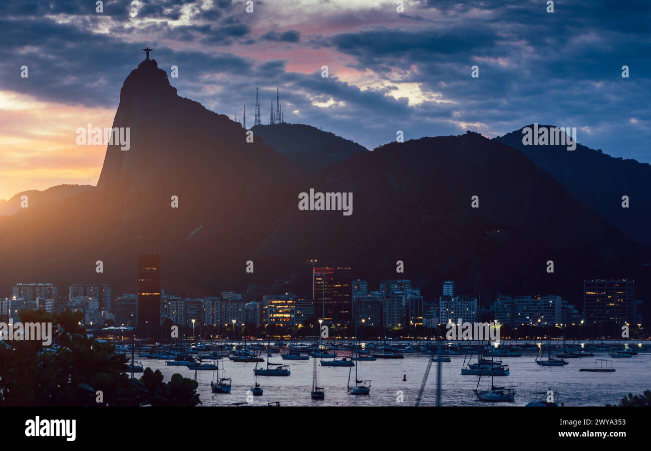 Vue sur la baie de Botafogo au coucher du soleil avec la statue du Christ Rédempteur en arrière-plan, site du patrimoine mondial de l'UNESCO, entre la montagne et la mer, inscrit Banque D'Images