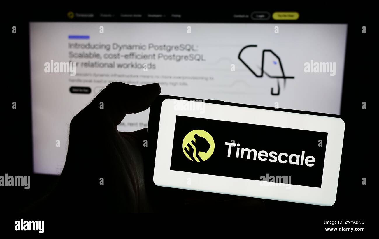 Personne tenant le téléphone portable avec le logo de la société américaine de logiciel de base de données Timescale Inc devant la page Web de l'entreprise. Concentrez-vous sur l'affichage du téléphone. Banque D'Images