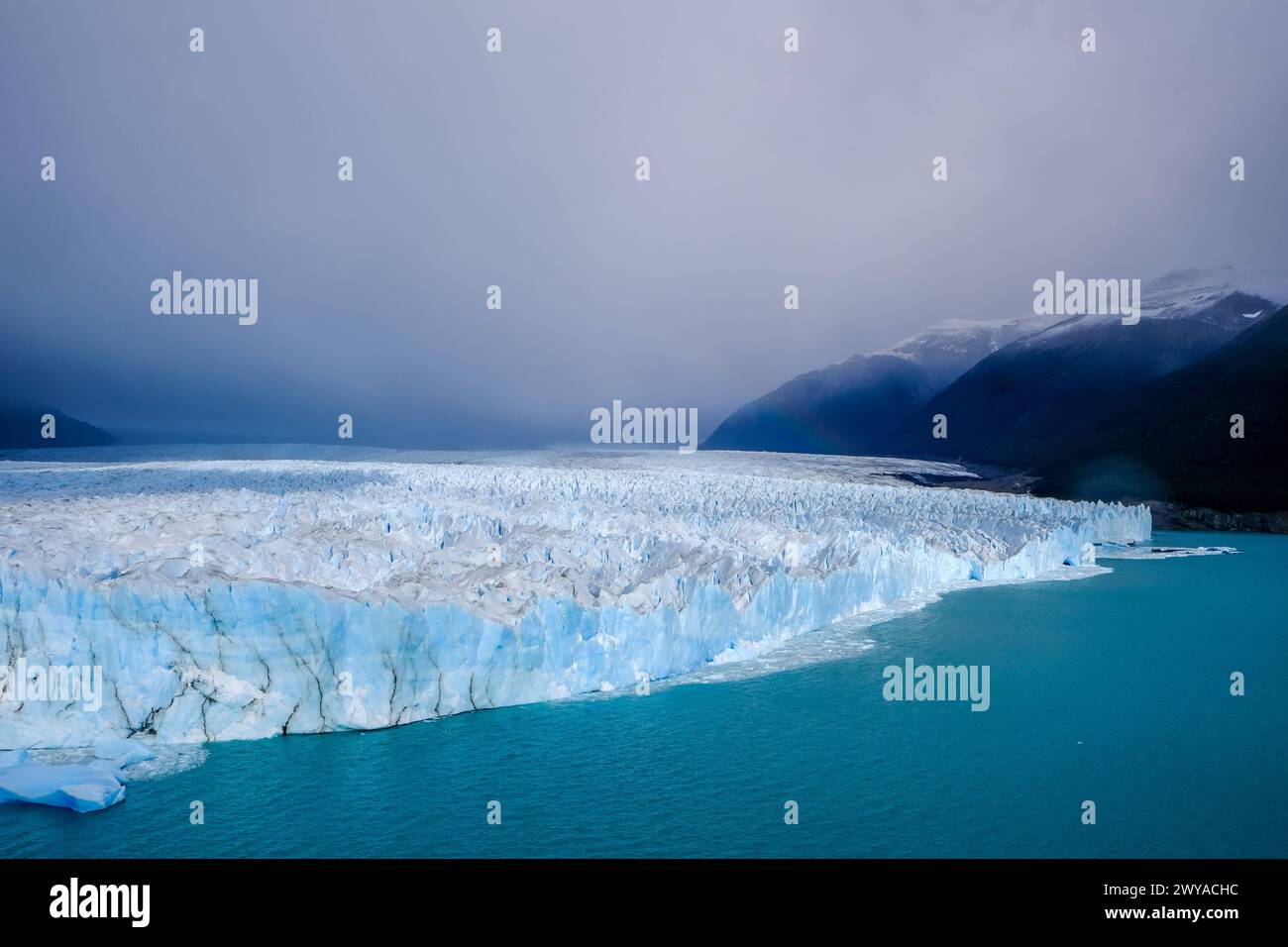 El Calafate, Patagonien, Argentinien - Perito Moreno Gletcher im Nationalpark Los Glaciares. Der Perito Moreno Gletscher gehoert zum patagonischen Eisfeld, dem Campo Hielo sur, der drittgroessten Suesswasserreserve der Welt. Er liegt in der Provinz Santa Cruz am Lago Argentino, dem groessten See des Landes. Der Perito Moreno Gletscher ist bis zu 30 km lang und 5 km breit. Seine Abbruchkante ist an der hoechsten Stelle 70 m hoch. Vom Gletscher abgebrochene kleine Eisberge treiben im Lago Argentino. Der Gletscher gehoert zu den schoensten Sehenswuerdigkeiten Suedamerikas und gilt als eine der me Banque D'Images