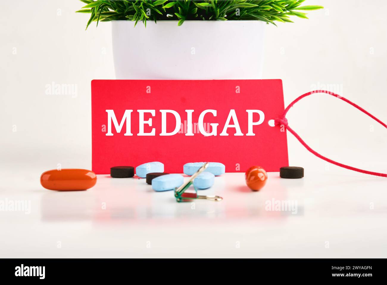 Concept médical. MEDIGAP sur un carton rouge avec des pilules couchées à côté Banque D'Images