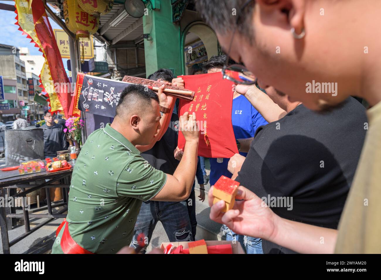 Un chaman taoïste se concentre sur l'écriture de caractères chinois pour une bénédiction sur drapeau rouge lors d'une cérémonie dans le temple Dongyue Hall Banque D'Images