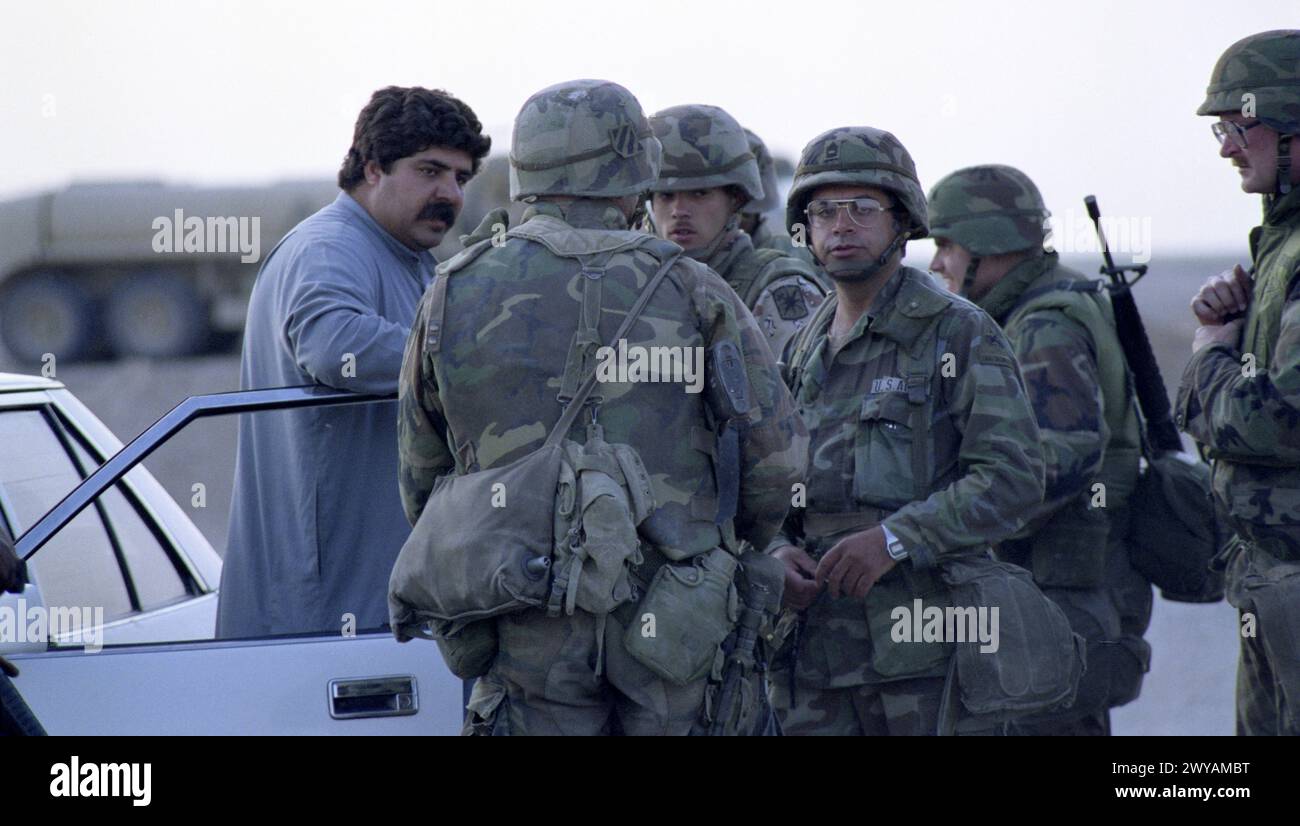 26 mars 1991 des soldats de l'armée américaine parlent avec un homme local au dernier poste de contrôle américain, à seulement 8 km au sud de Nasiriyah dans le sud de l'Irak. Banque D'Images